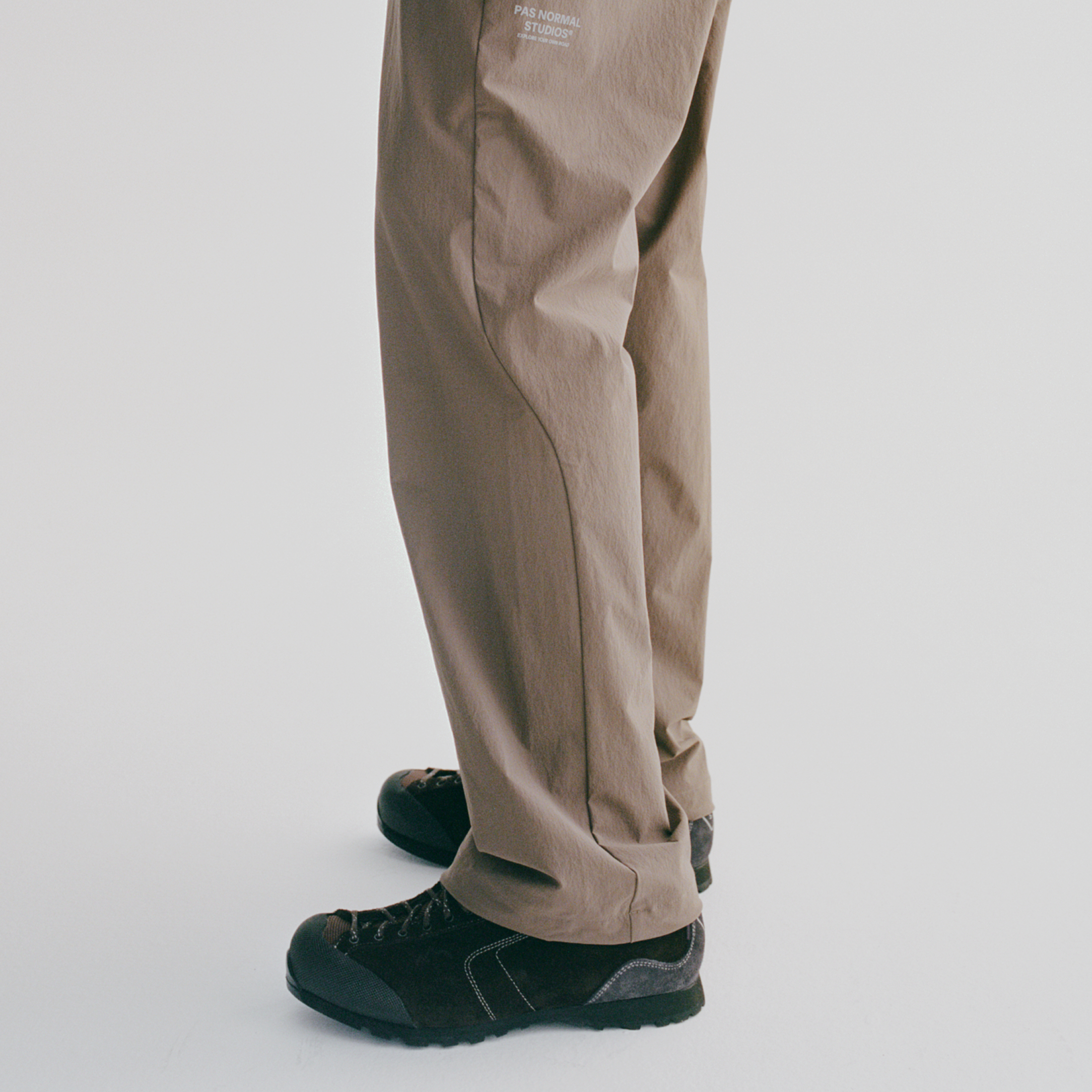 Model wearing beige casual pants with logo branding and dark green Diemme sneakers
