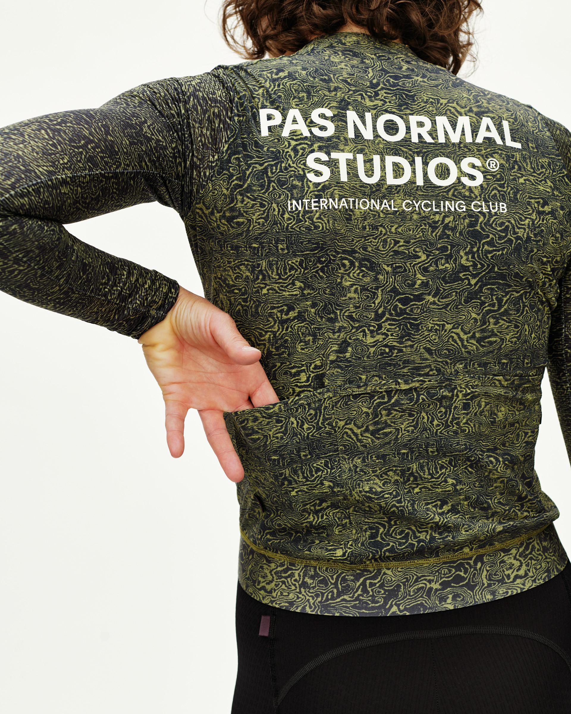 Dark Lime Essential long sleeve cycling jersey on model, rear view with topo print and white back logo