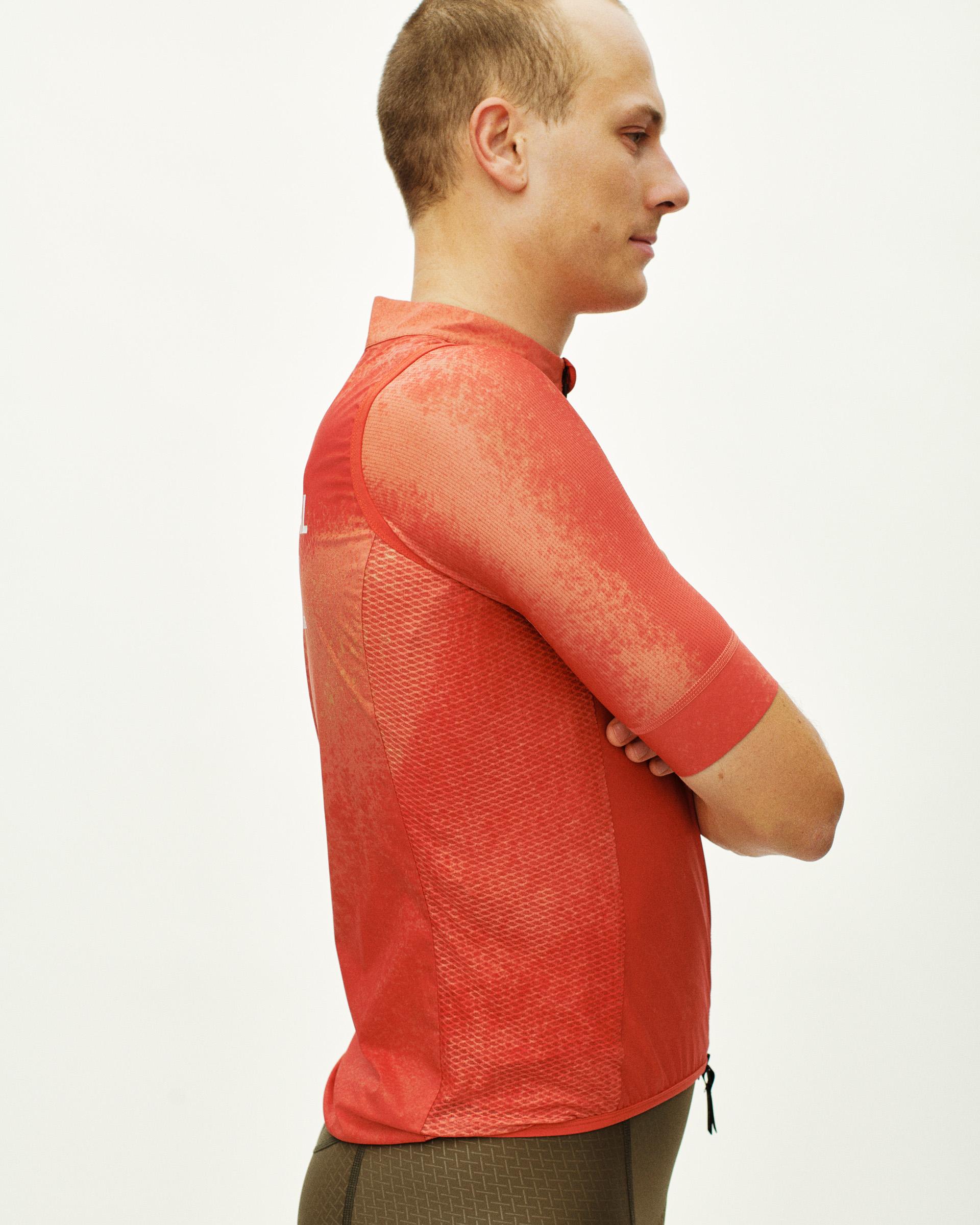 Orange Mechanism Stow Away gilet on model, side view with mesh body panels