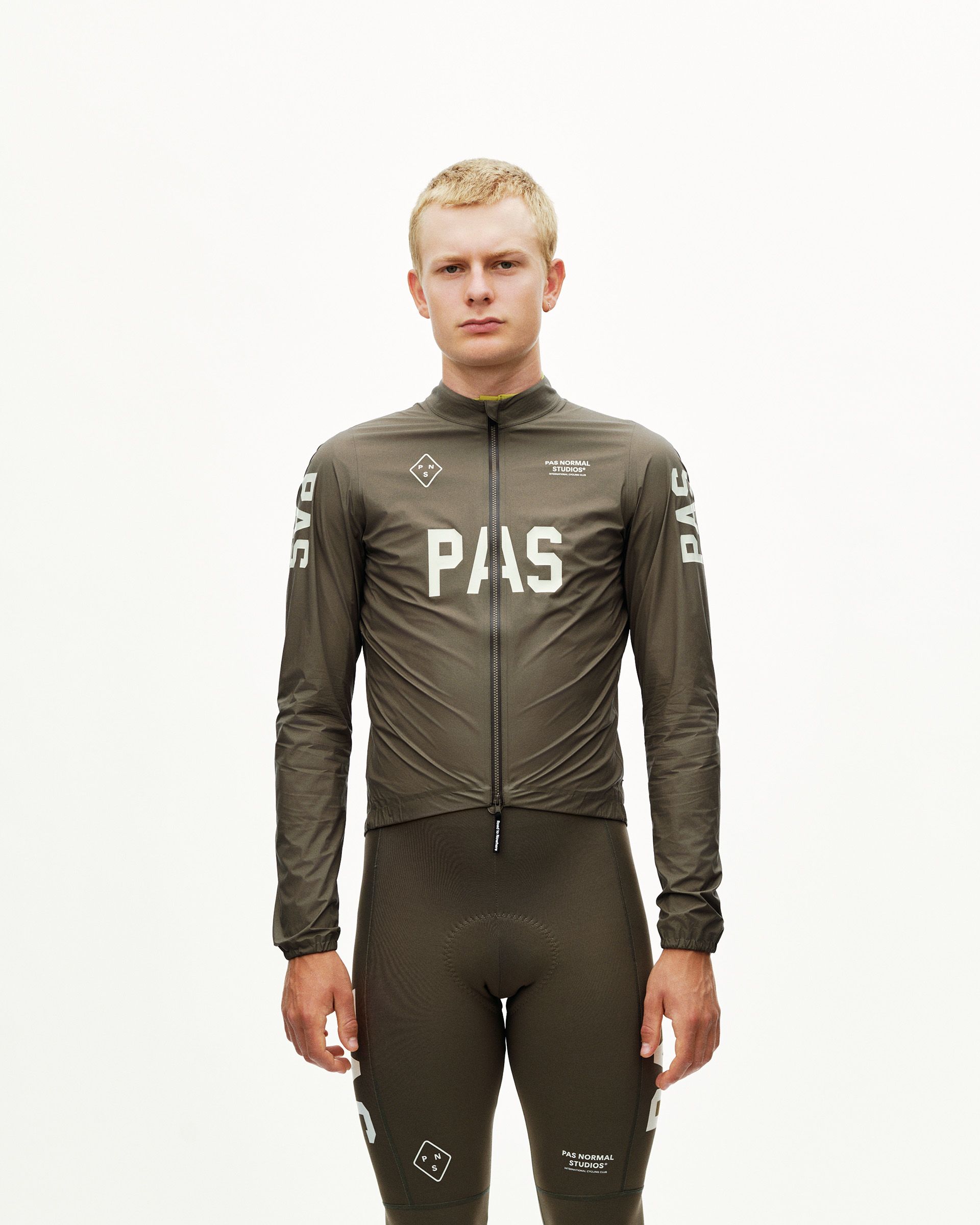 Dark Earth khaki PAS Mechanism cycling rain jacket on model, front view with large chest logo print