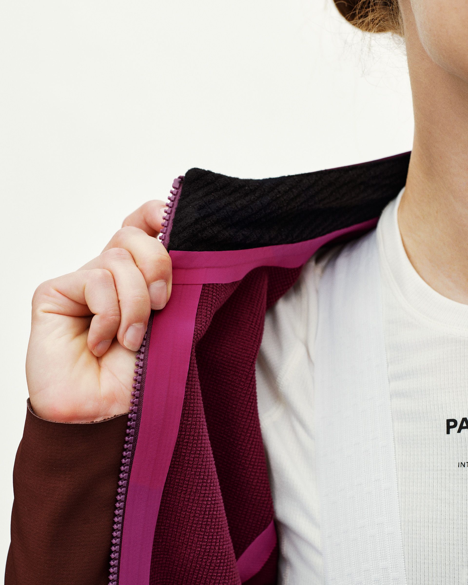 Dark Purple PAS Mechanism women's cycling jacket, detail view of open zip showing fleece lining and pink zip tape