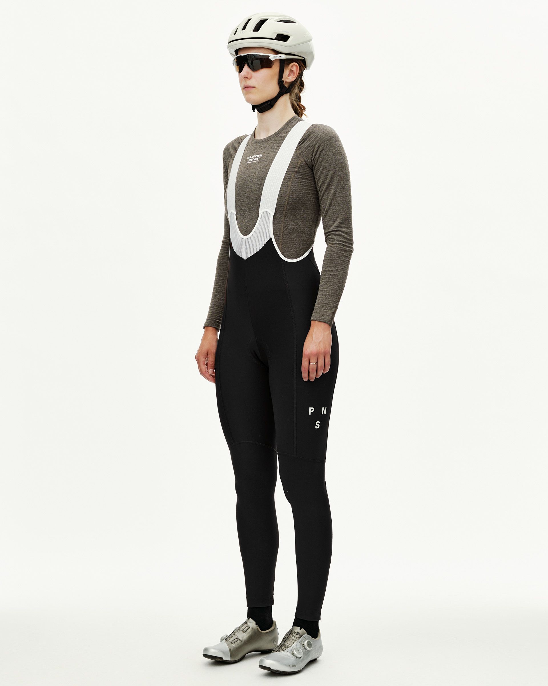 Black Mechanism women's thermal cycling long bibs on model, three-quarter front view with white bib straps