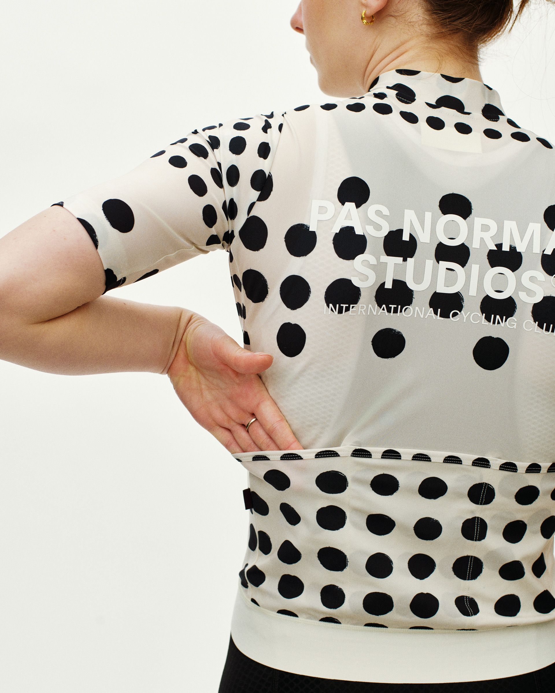 Off White Essential women's cycling jersey, rear view on model with black dot print and back pocket panel