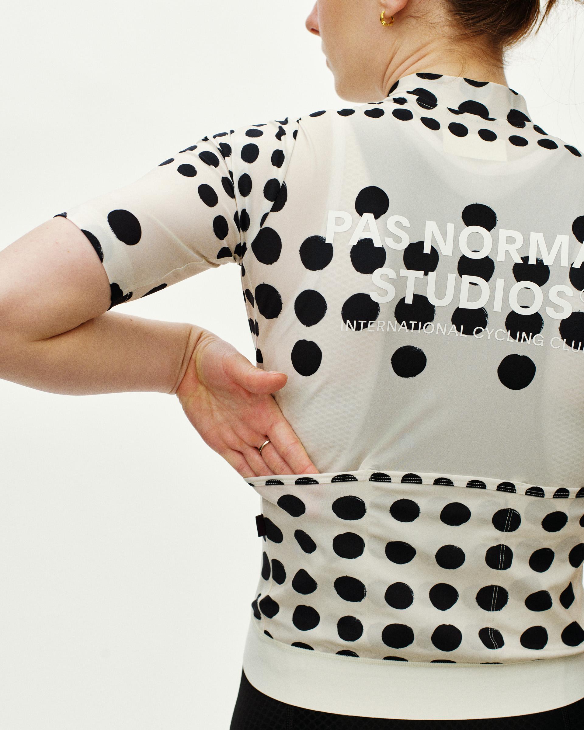Off White Essential women's cycling jersey, rear view on model with black dot print and back pocket panel