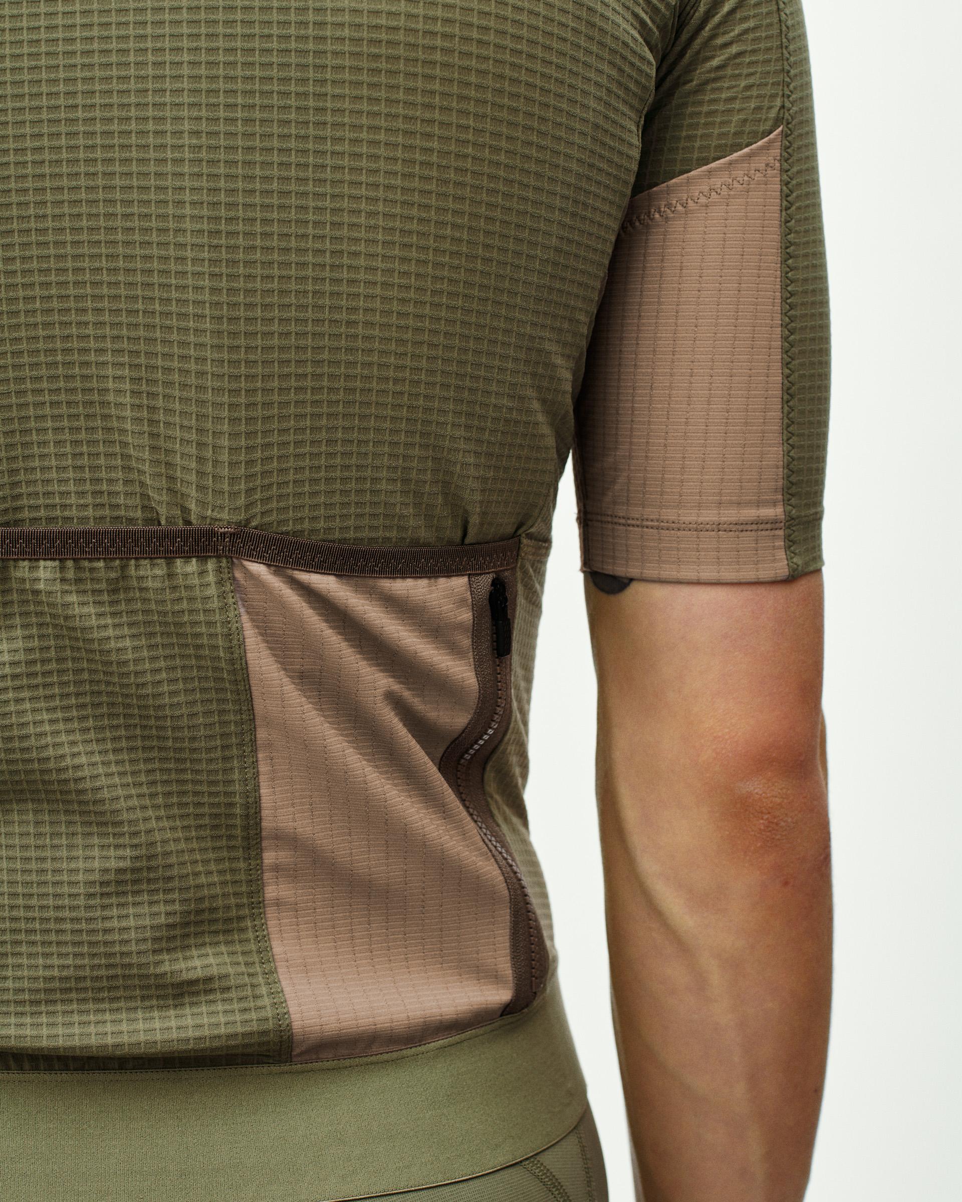 Light Olive Escapism cycling jersey on model showing contrast tan side panels and rear pockets