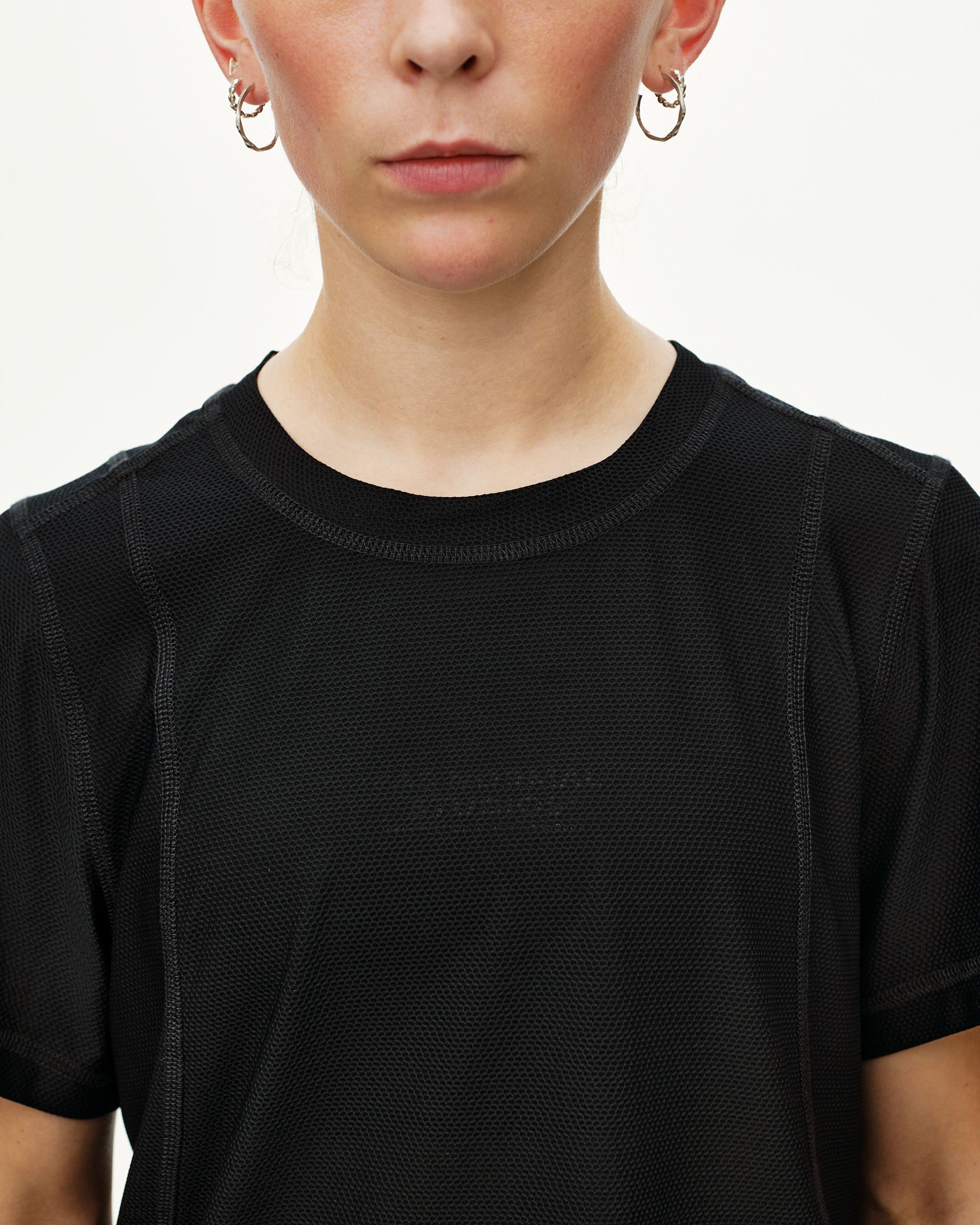 Black Balance T-Shirt on model, front detail view with textured mesh fabric and tonal chest print