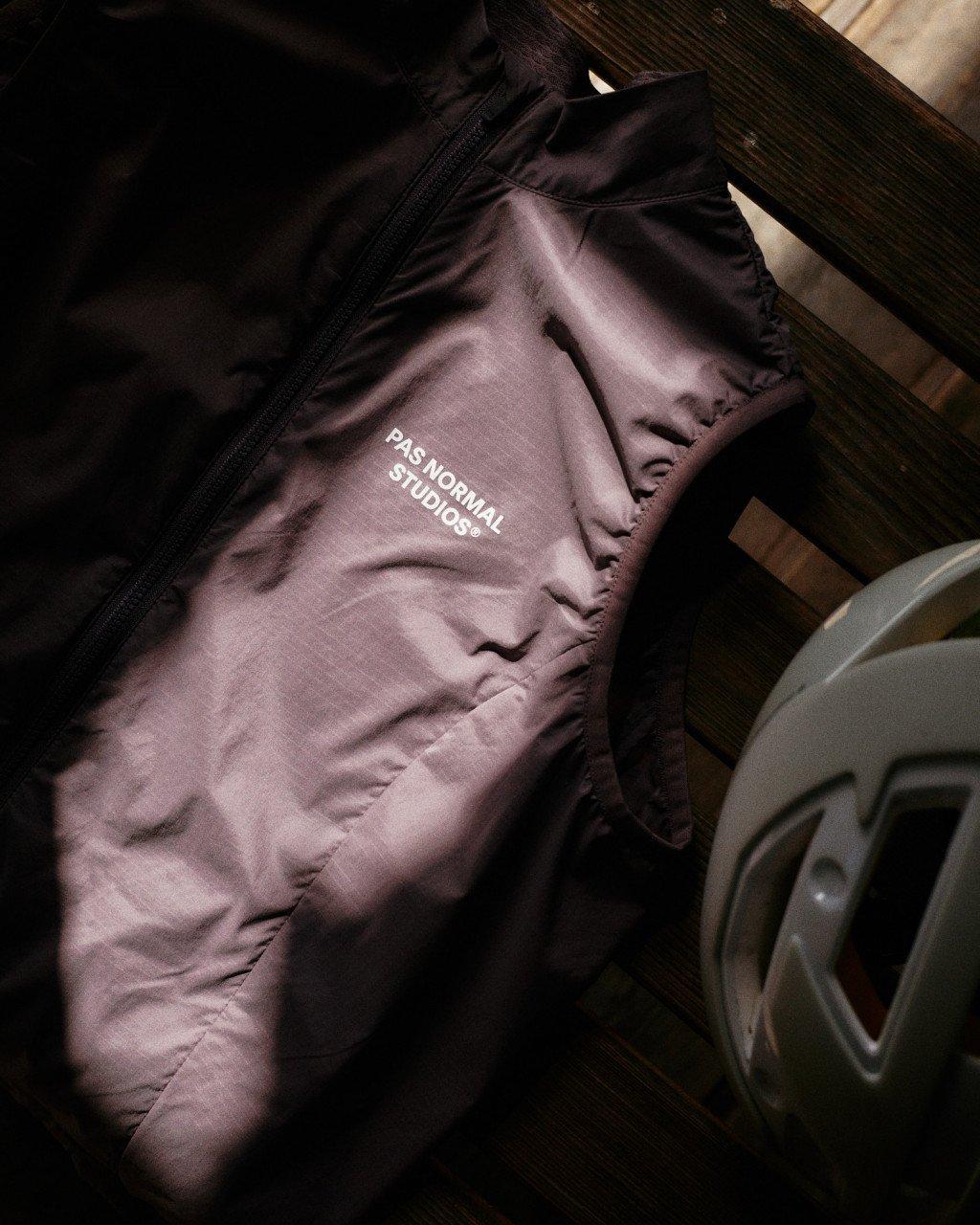 Purple jacket with white branding laid flat in wooden storage compartment