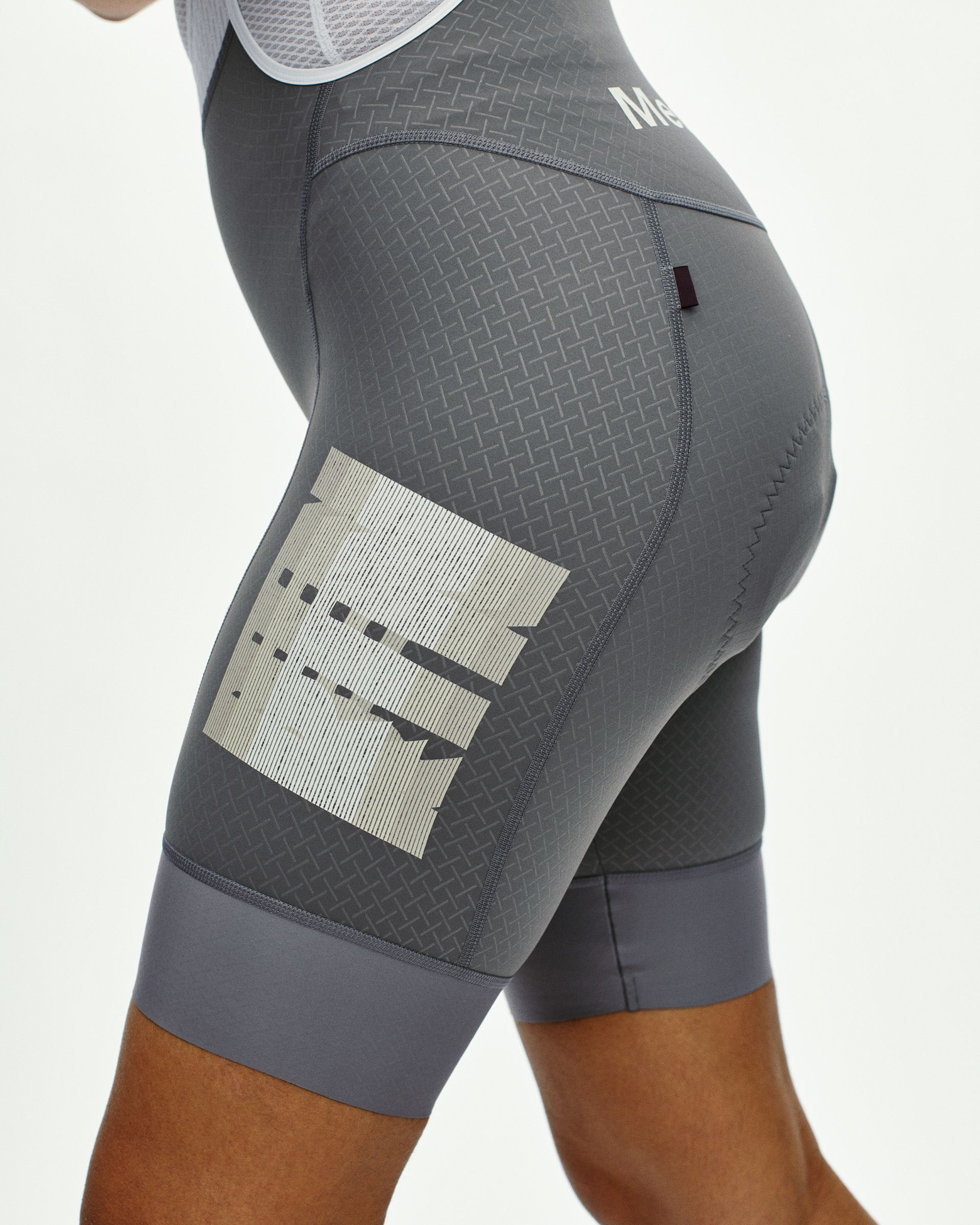 Medium Grey Mechanism women's cycling bibs, side view on model with graphic thigh print