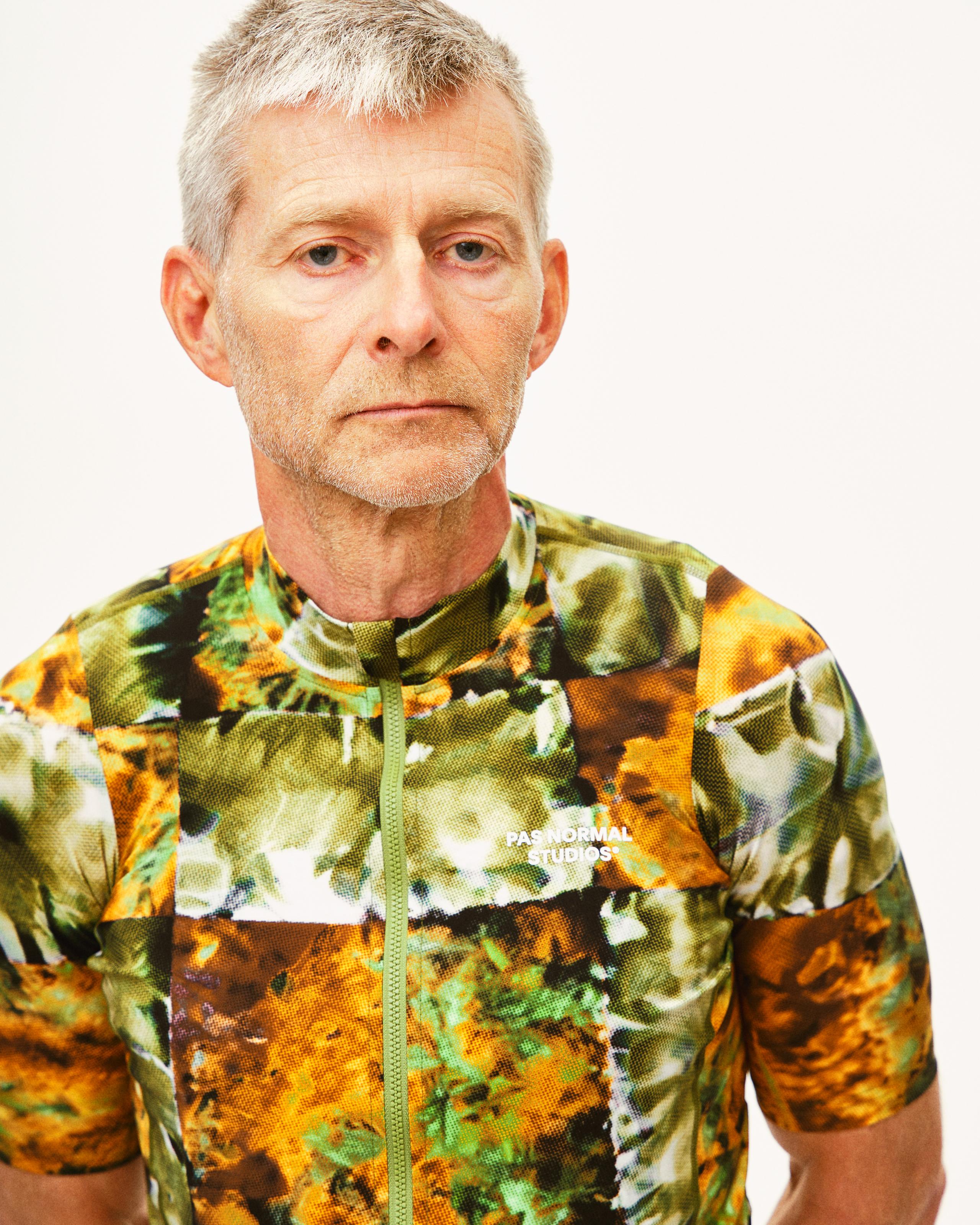 Green Essential cycling jersey on model with abstract kaleidoscope print and full zip