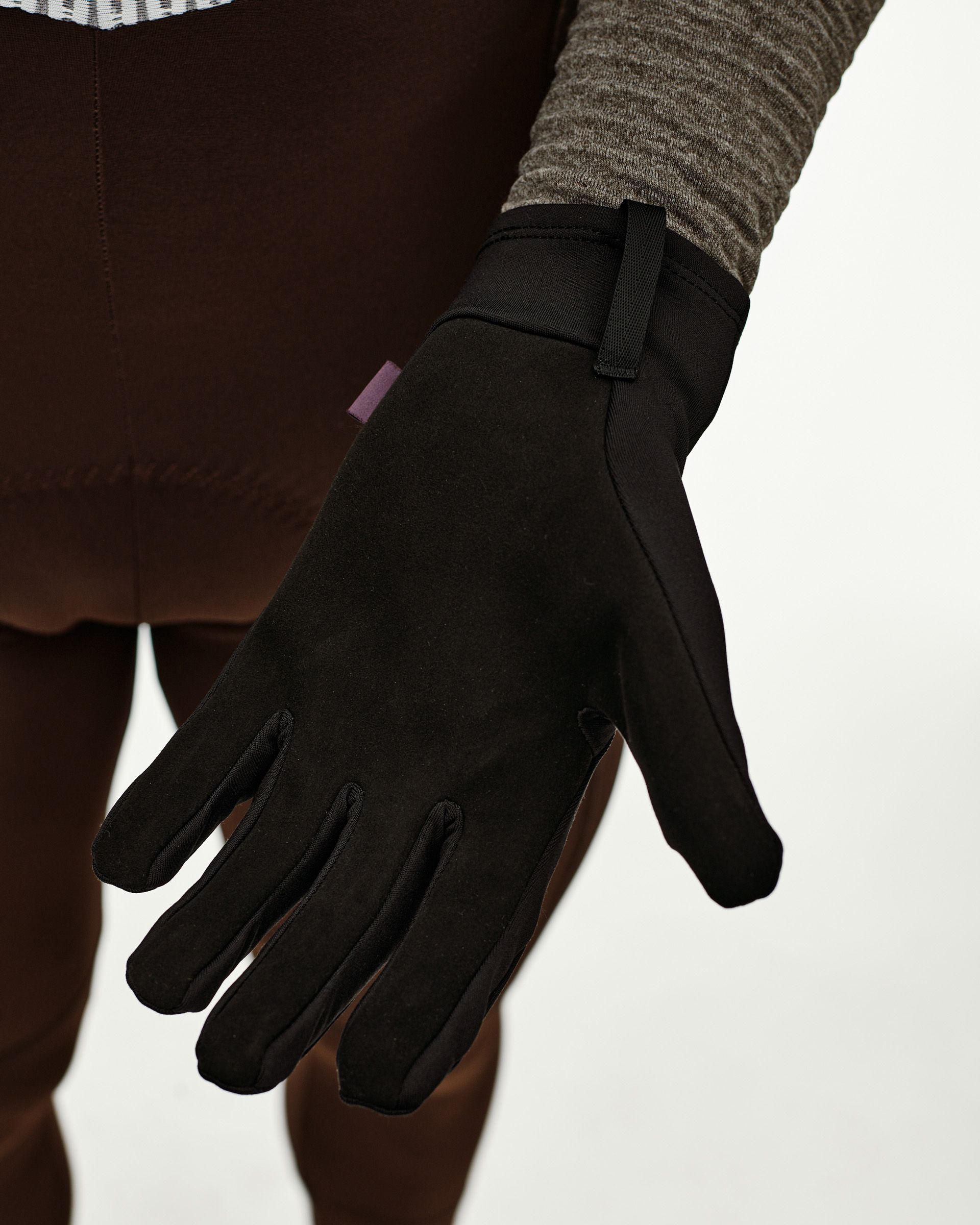 Black Logo Light cycling glove on model, palm-side detail view with pull tab at cuff