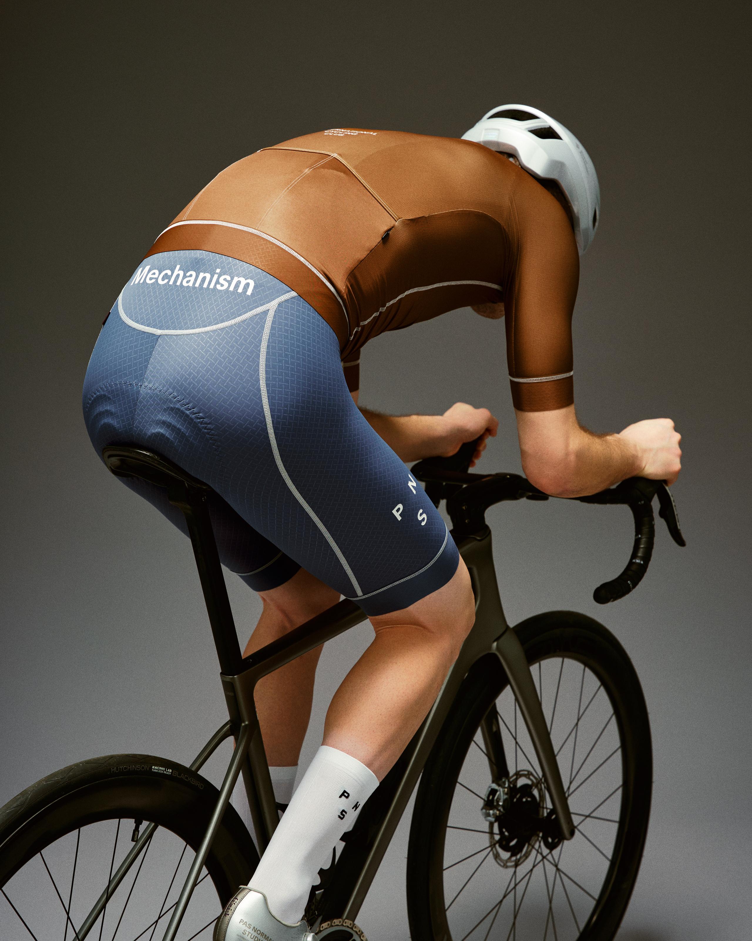 Brown Mechanism cycling jersey on model in aerodynamic position with contrast stitching