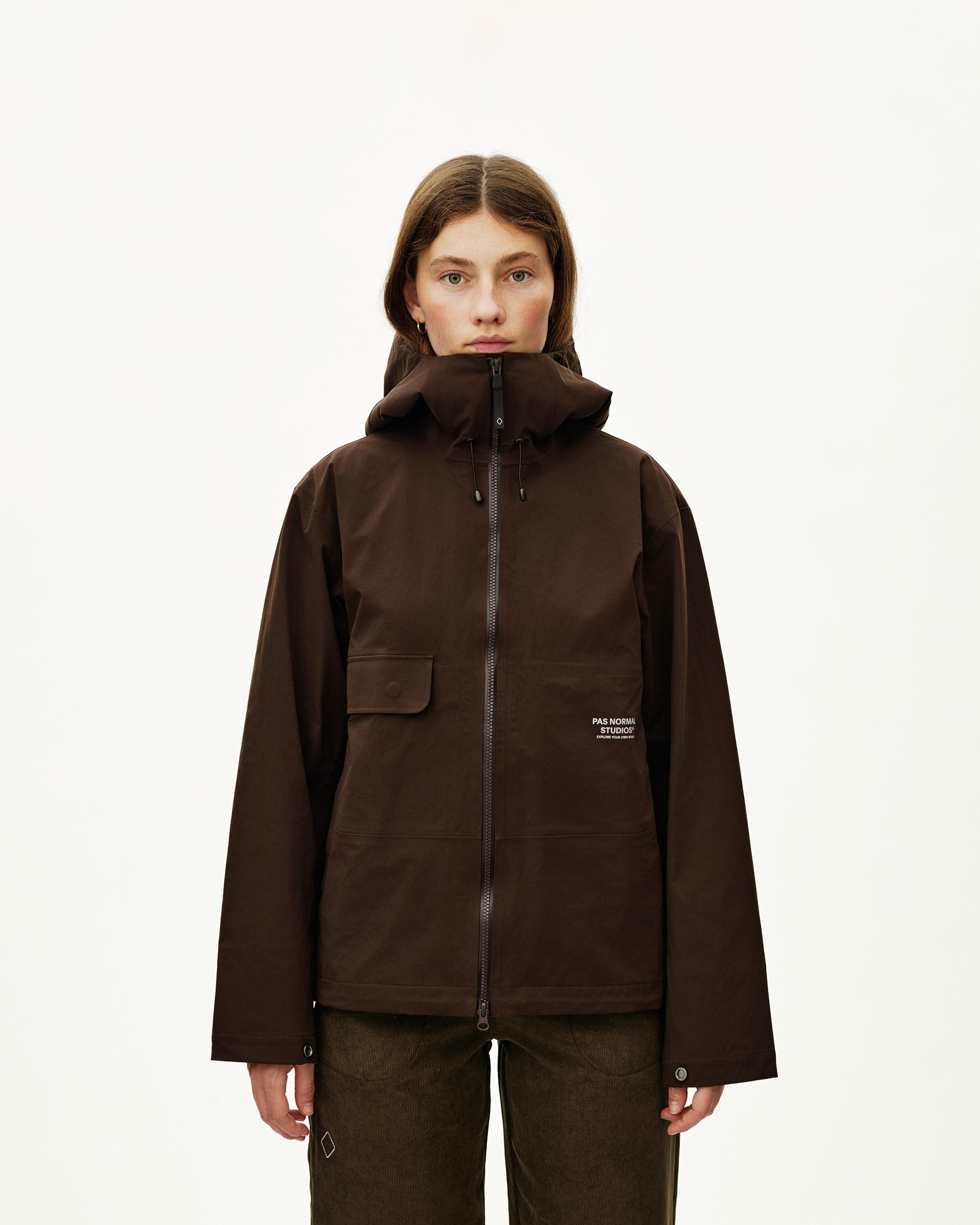 Dark Coffee Off-Race 3L Shell jacket on model, front view with storm hood and chest patch pocket