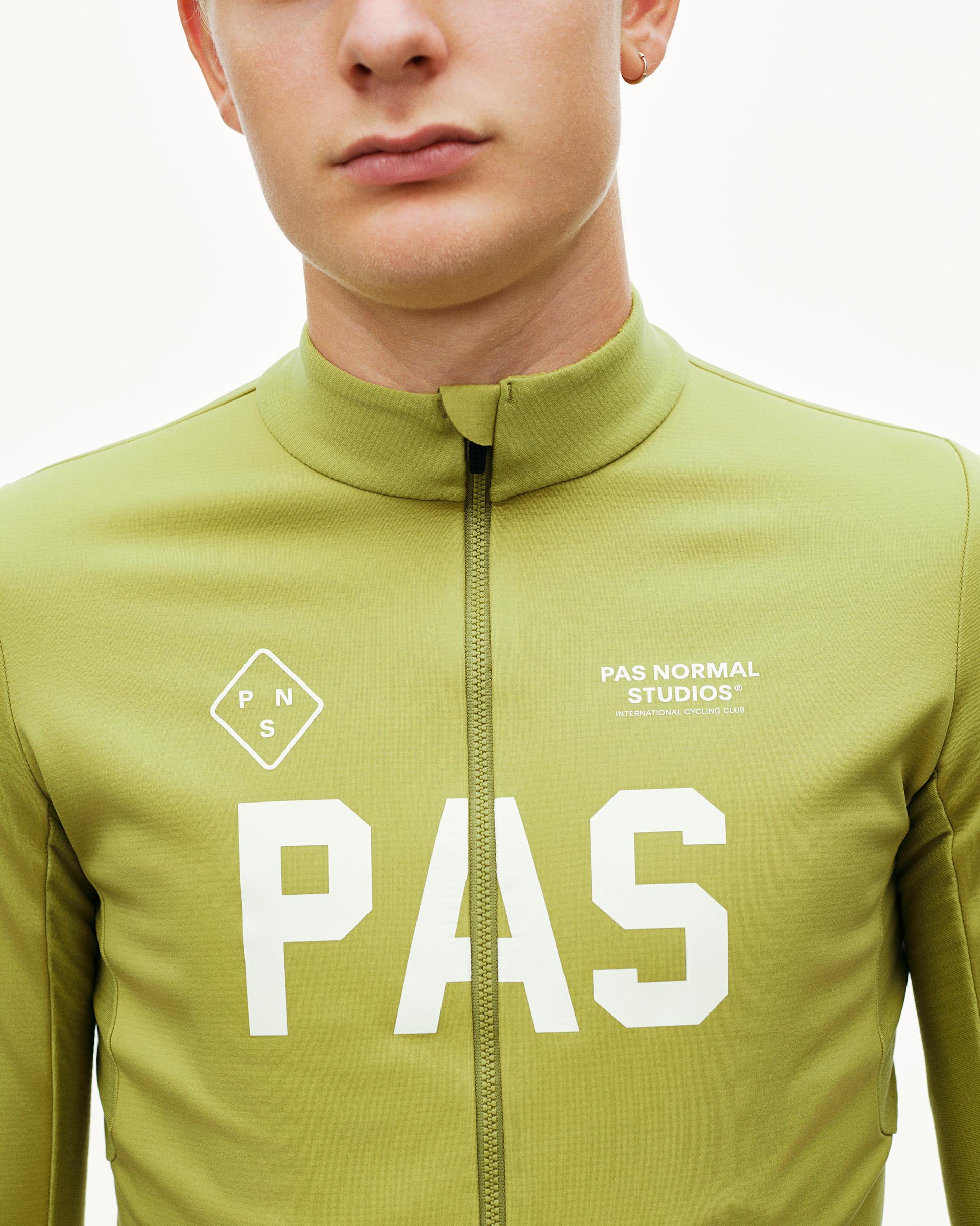 Dark Lime PAS Mechanism Thermal long sleeve cycling jersey, front detail on model with large white PAS chest print