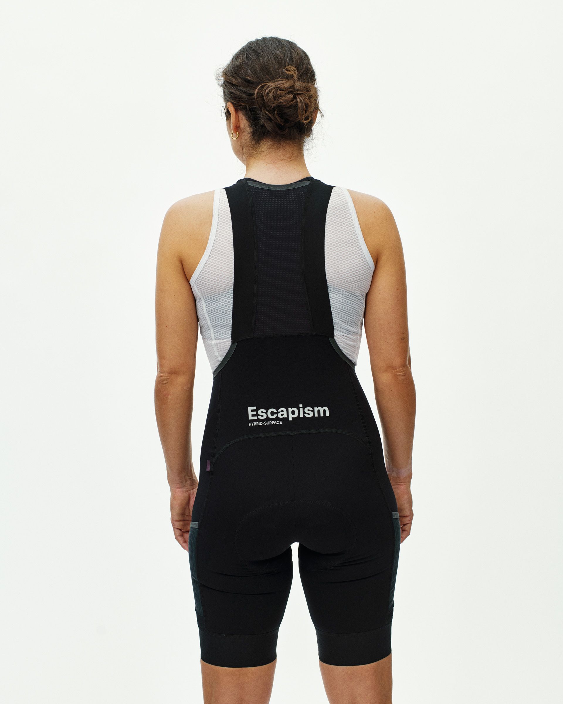 Black Escapism Cargo cycling bibs on model, rear view with white mesh side panels and chest branding