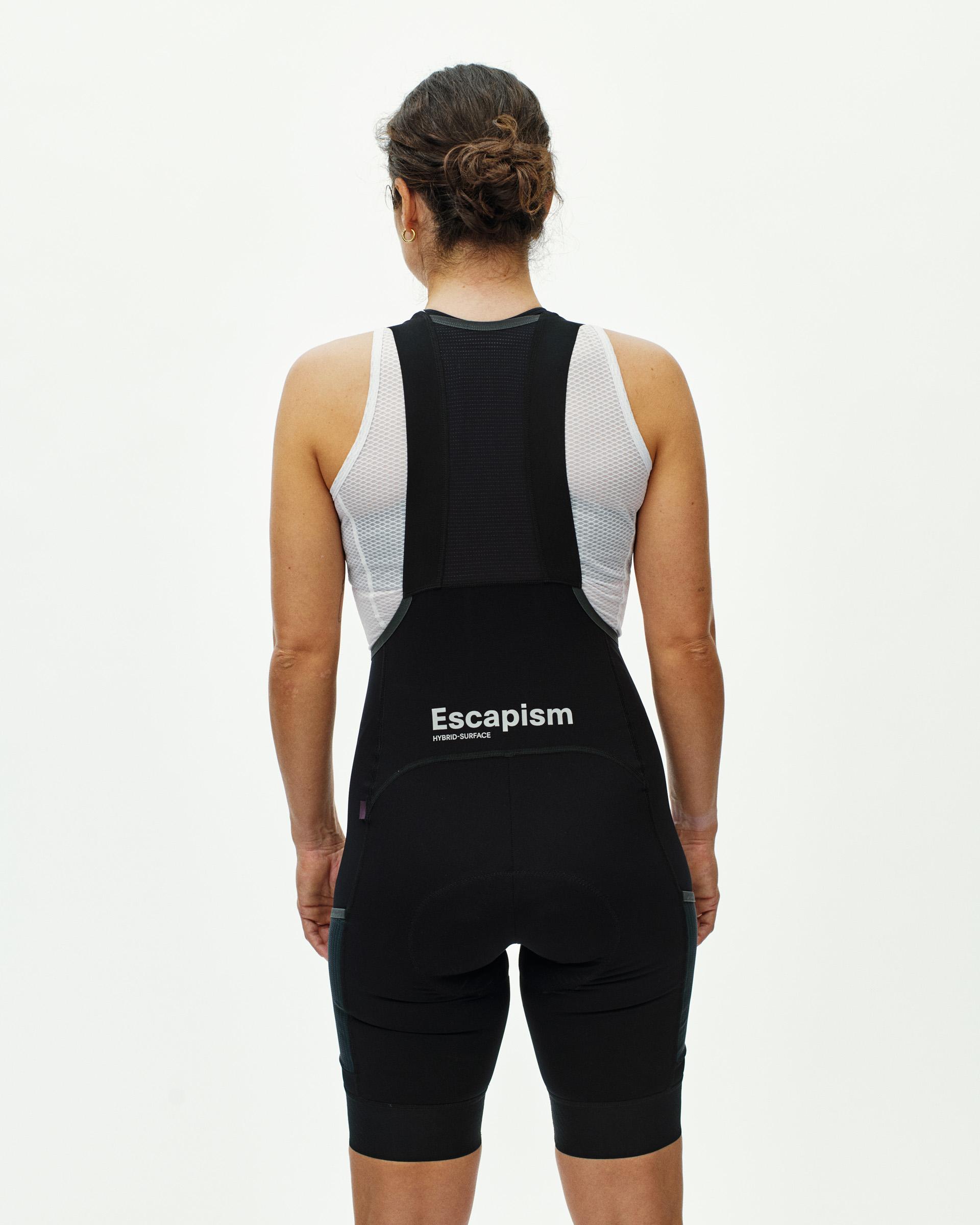 Black Escapism Cargo cycling bibs on model, rear view with white mesh side panels and chest branding
