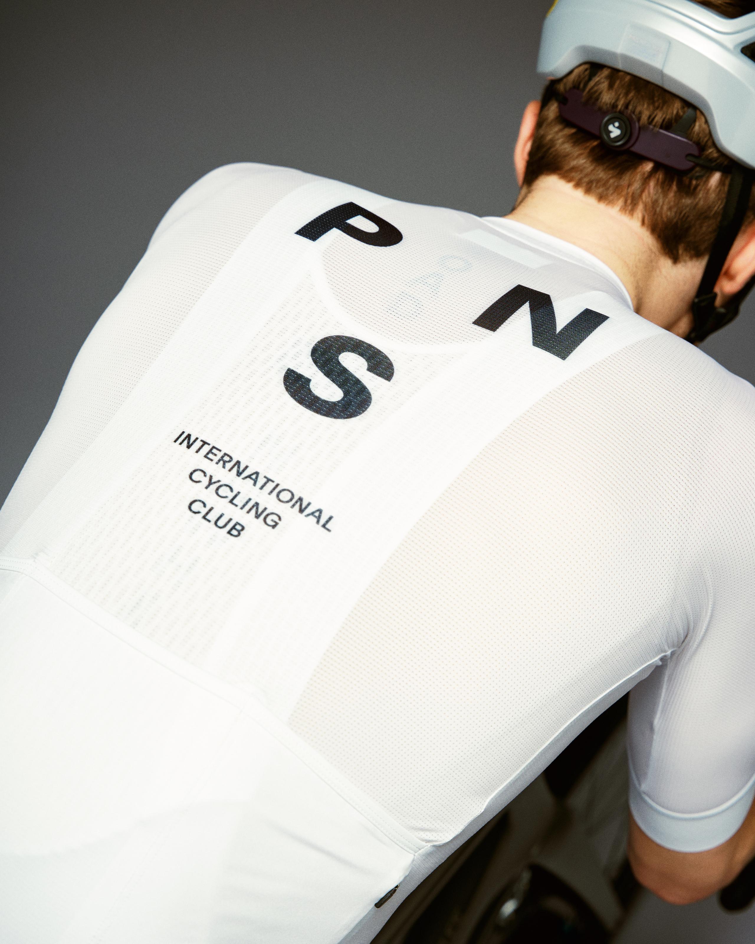 White Mechanism cycling jersey on model, rear view with black PNS International Cycling Club back print