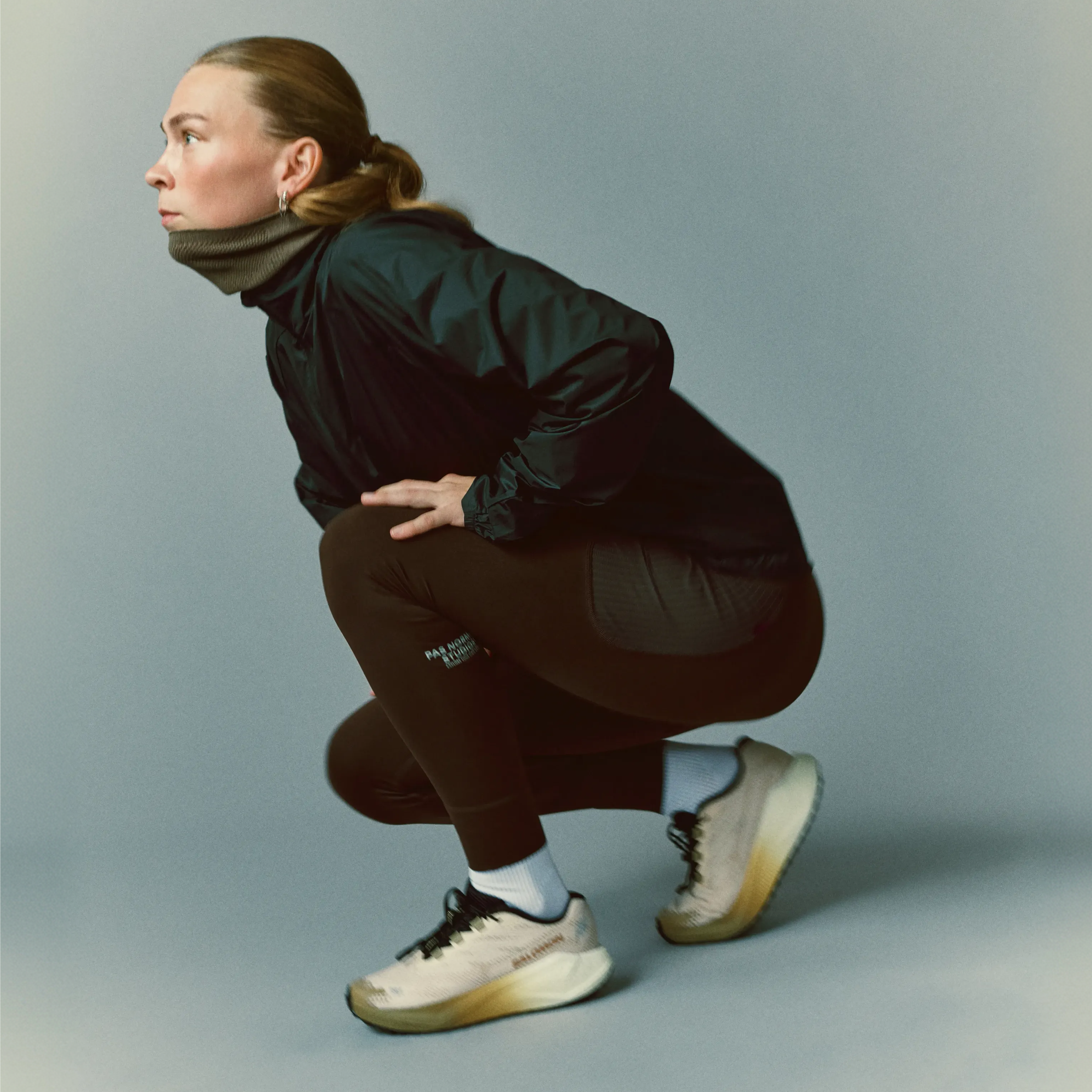 Dark Brown Balance women's shorts on model in cropped squat pose, side view with ribbed hem