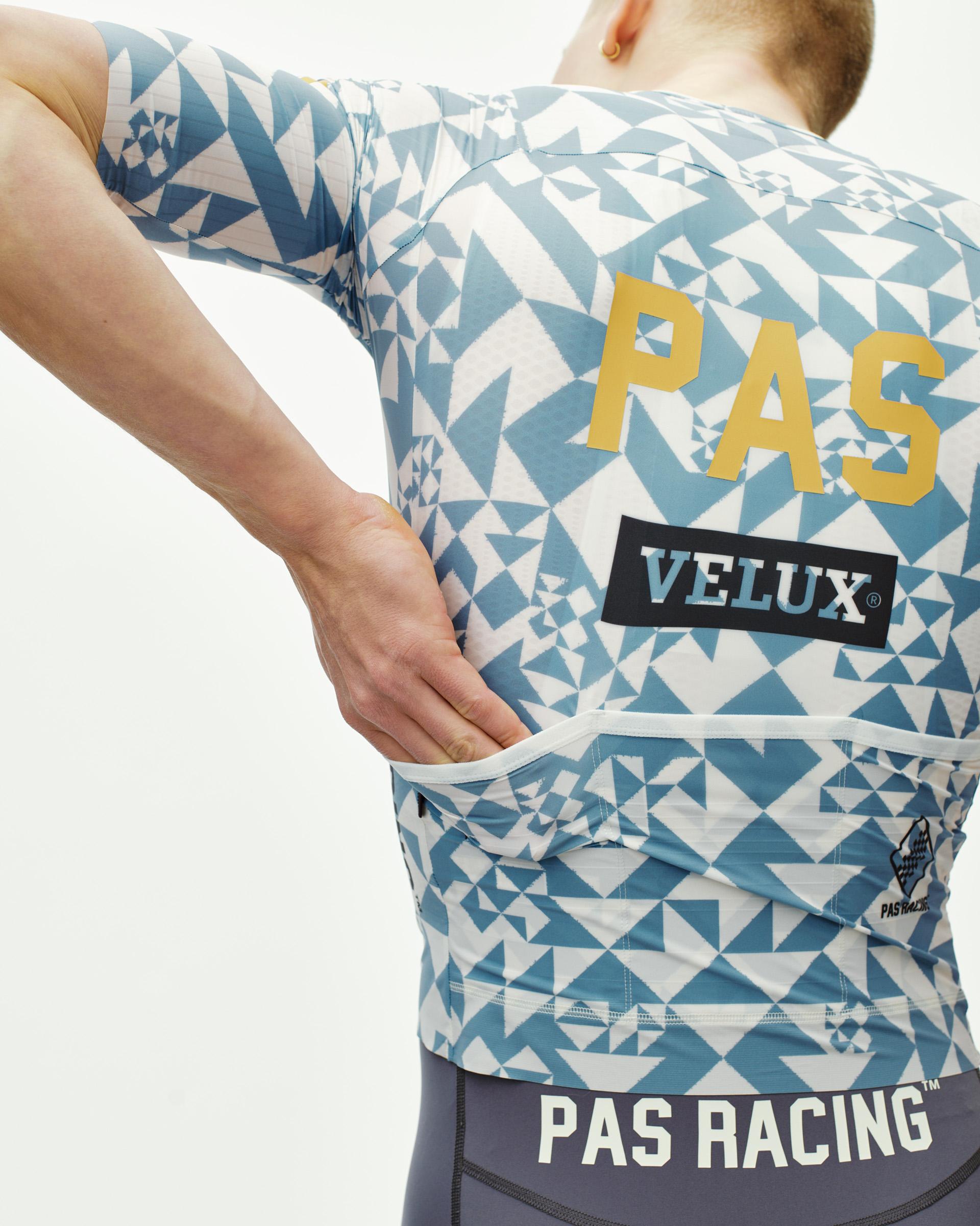Origami Light Blue PAS Mechanism Pro cycling jersey on model, rear view with geometric print and gold PAS back print