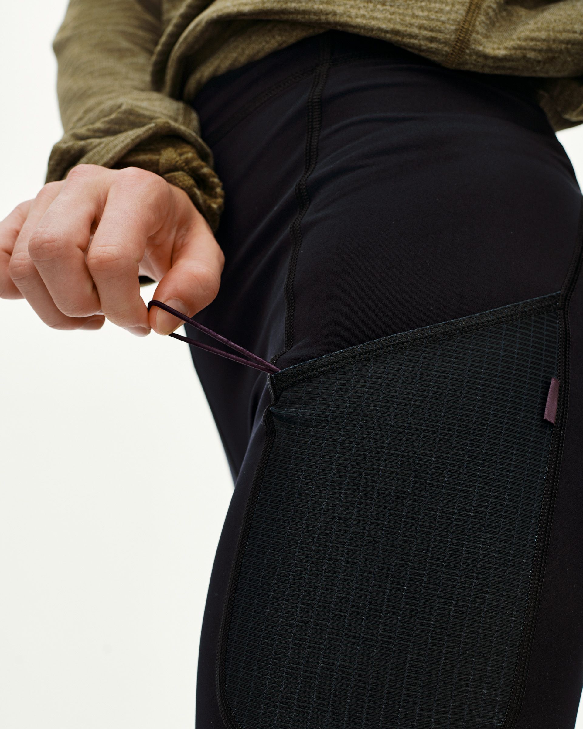 Black Balance Women's Long Tights, detail view on model showing textured side panel with purple elastic loop