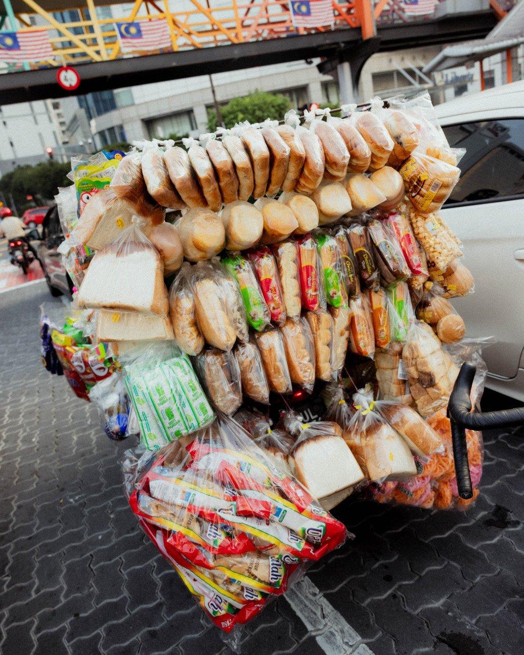 Mobile bread vendor cart loaded with various packaged breads and baked goods on Singapore street