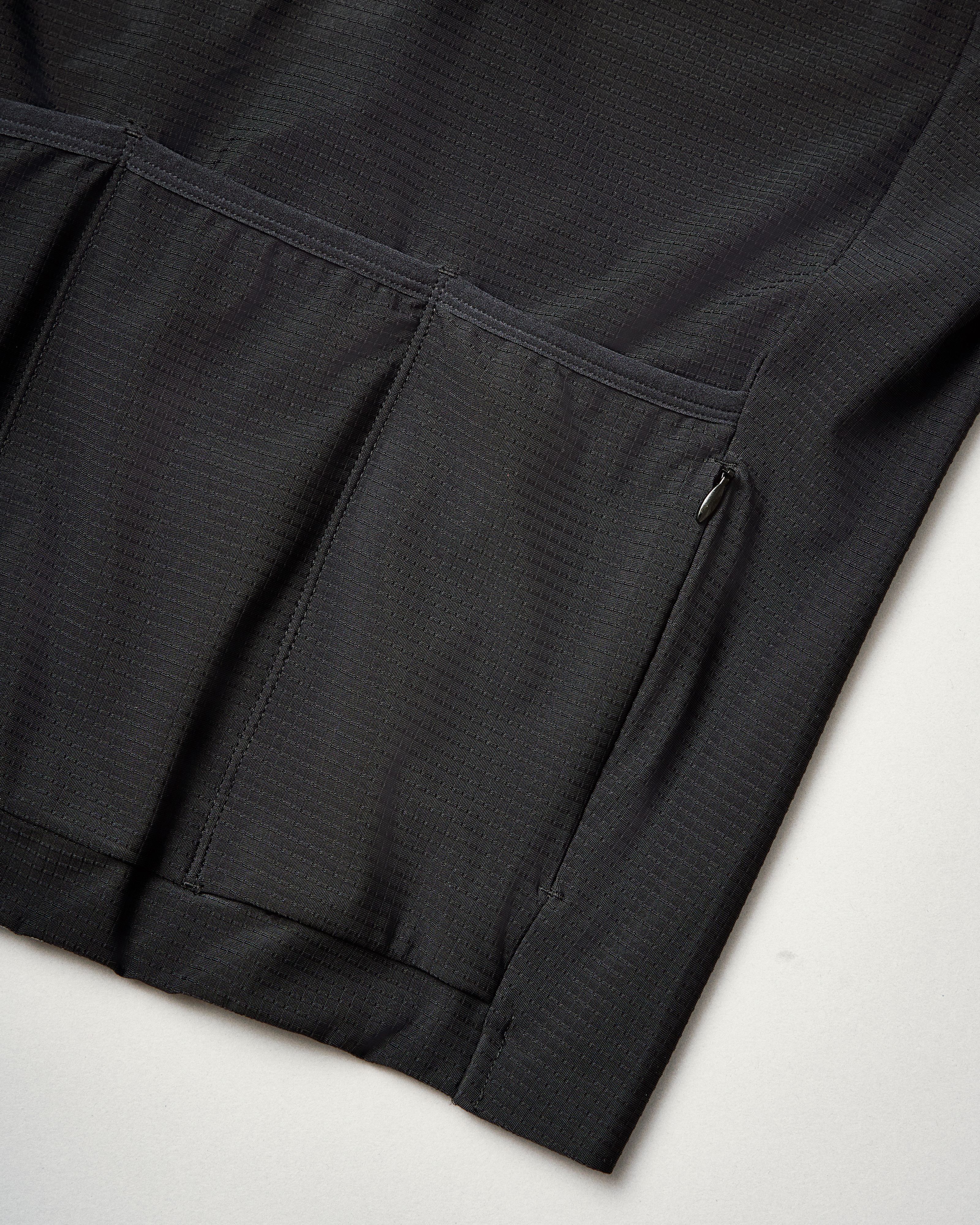Black PAS Mechanism Pro long sleeve cycling jersey, detail view showing side pocket with zip closure