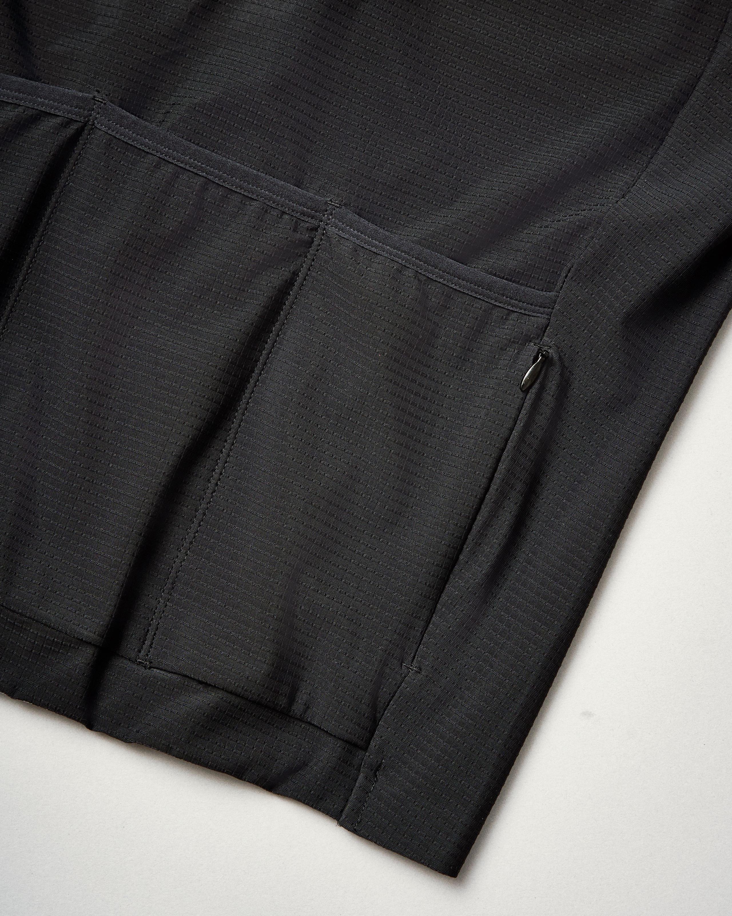 Black PAS Mechanism Pro long sleeve cycling jersey, detail view showing side pocket with zip closure
