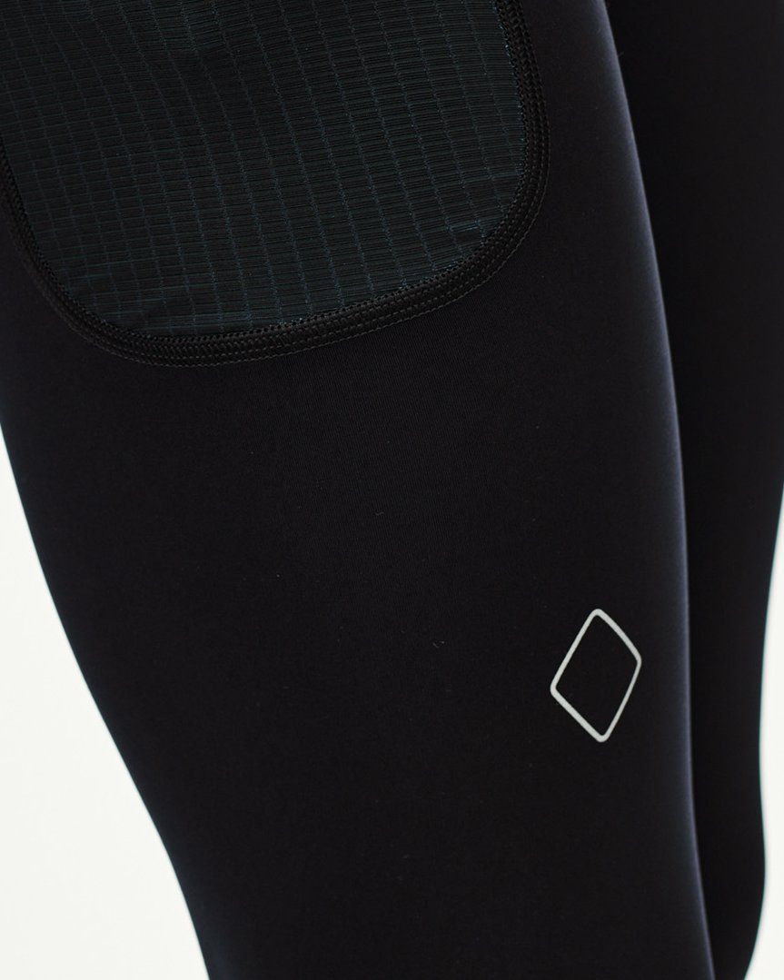 Black Balance long tights, detail view showing textured knee panel and diamond logo