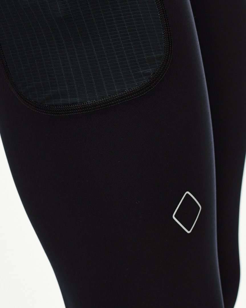 Black Balance long tights, detail view showing textured knee panel and diamond logo