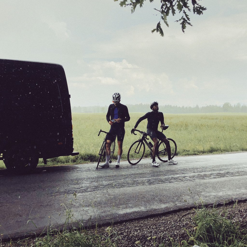 Two cyclists with bikes during countryside break beside van