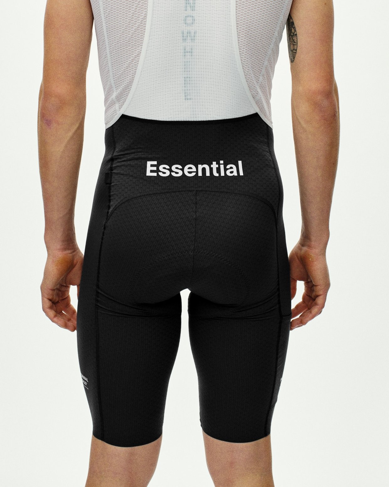 Black Essential Light Cargo bibs, rear view on model with white Essential logo on waistband