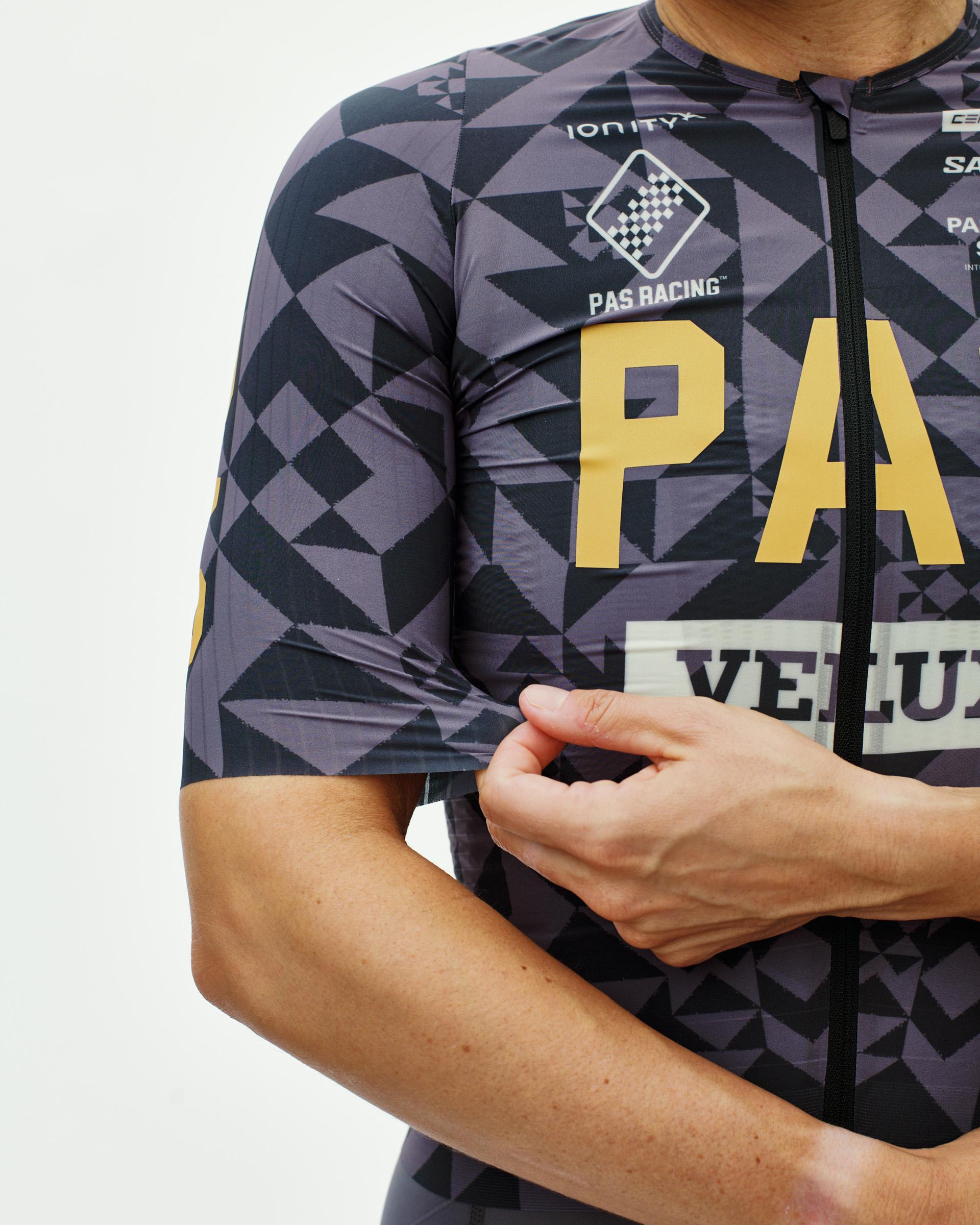 Origami Grey PAS Mechanism Pro women's cycling jersey, front detail on model with geometric print and gold chest lettering