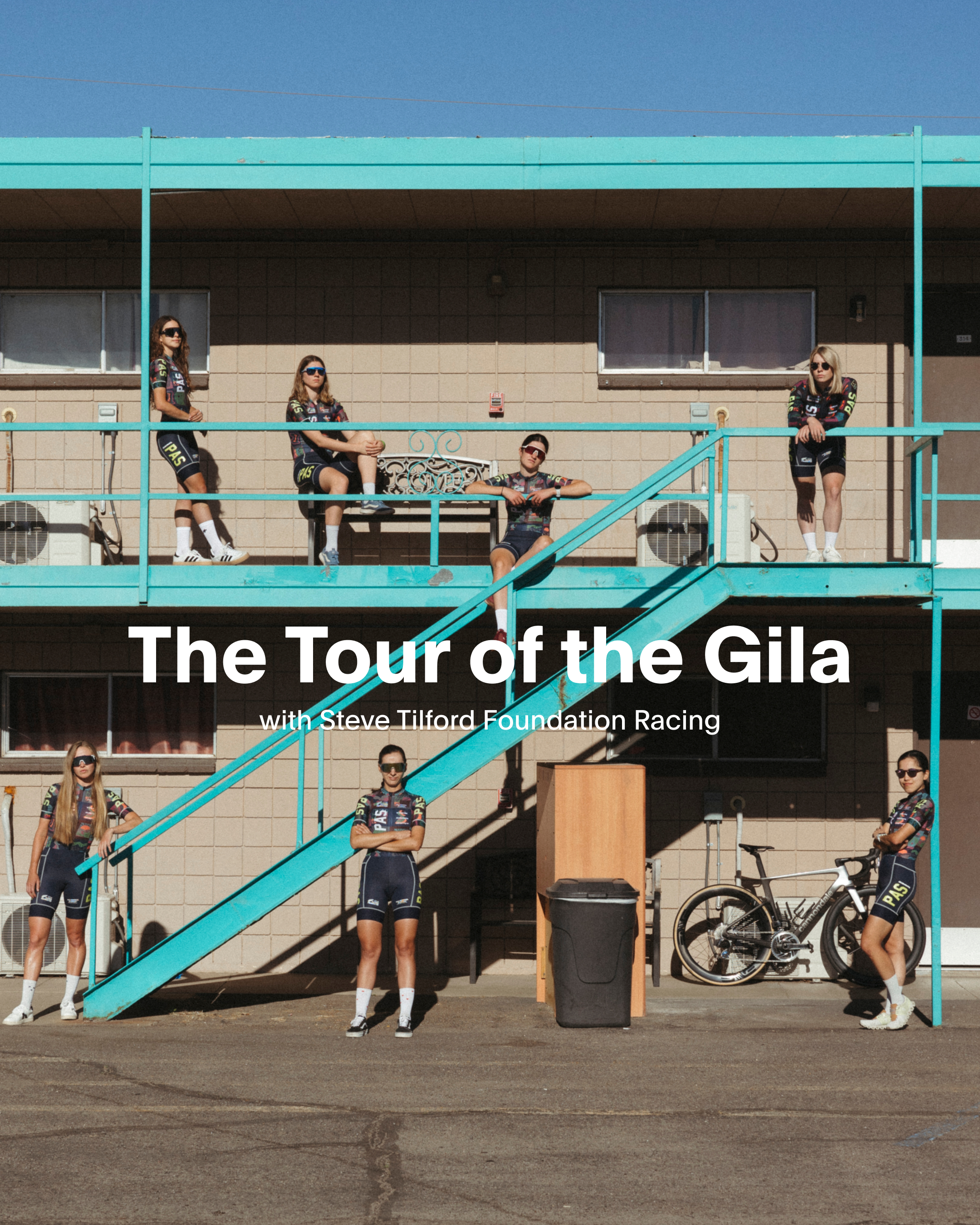 Models wearing Tour of the Gila cycling apparel on turquoise staircase with race bike