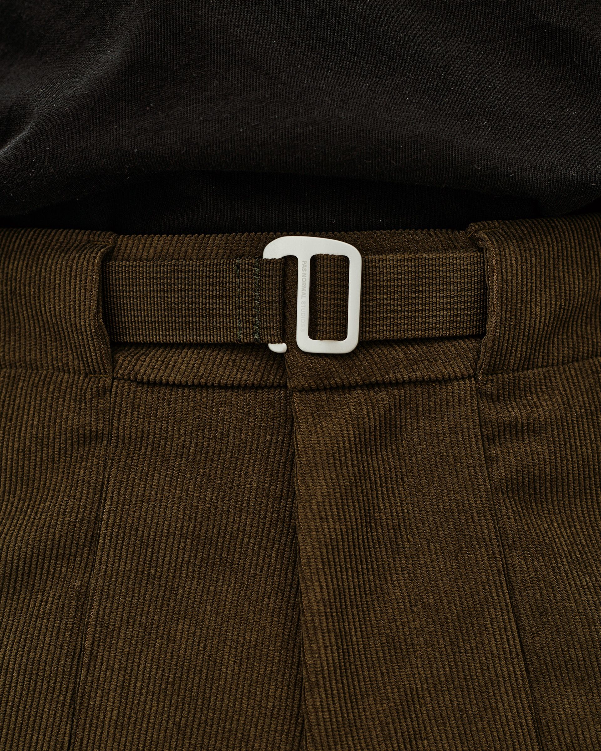 Deep Olive Off-Race Corduroy pants, detail view of waistband with webbing belt and white buckle clasp