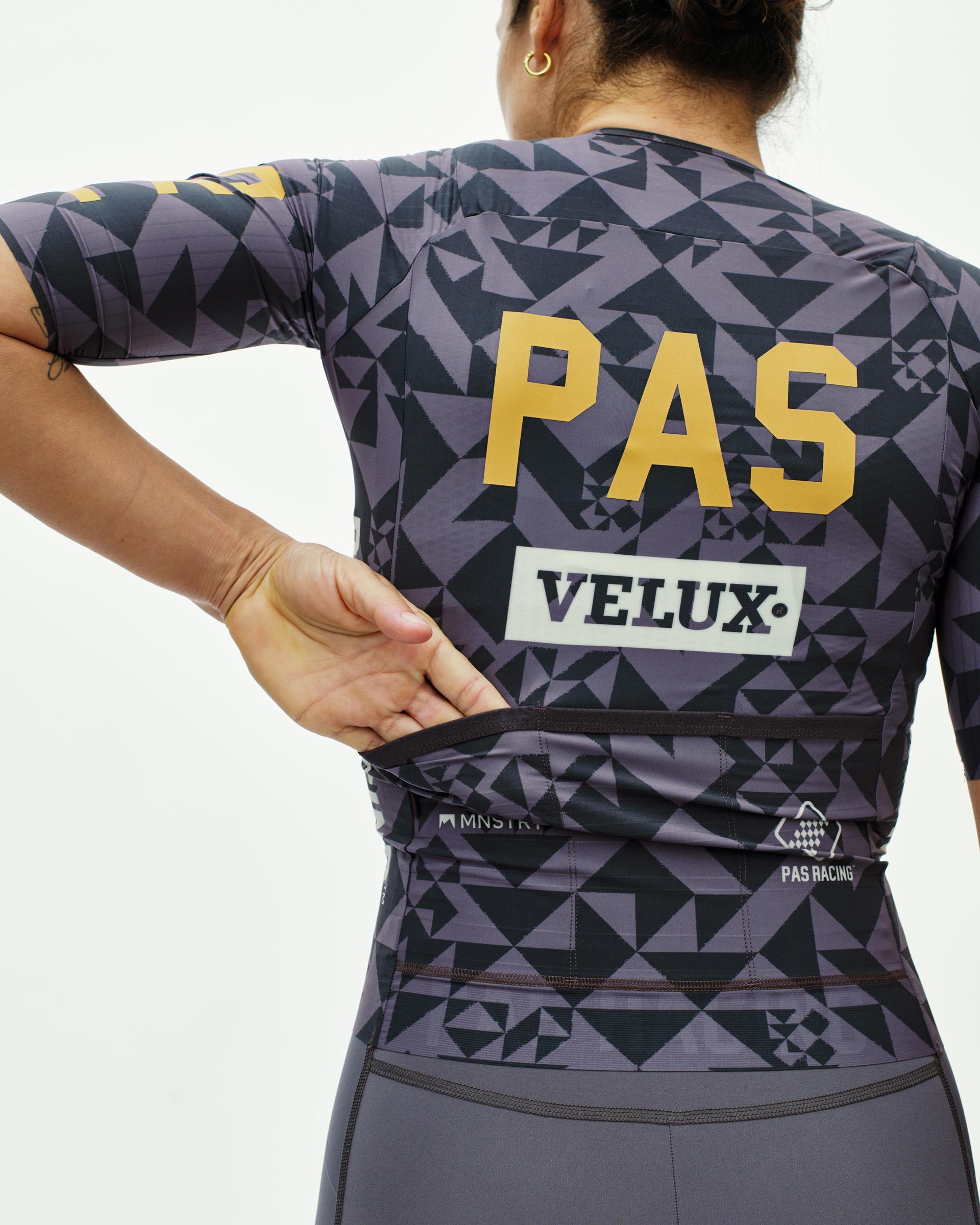 Origami Grey PAS Mechanism Pro women's cycling jersey, rear view on model with geometric print and gold PAS back graphic