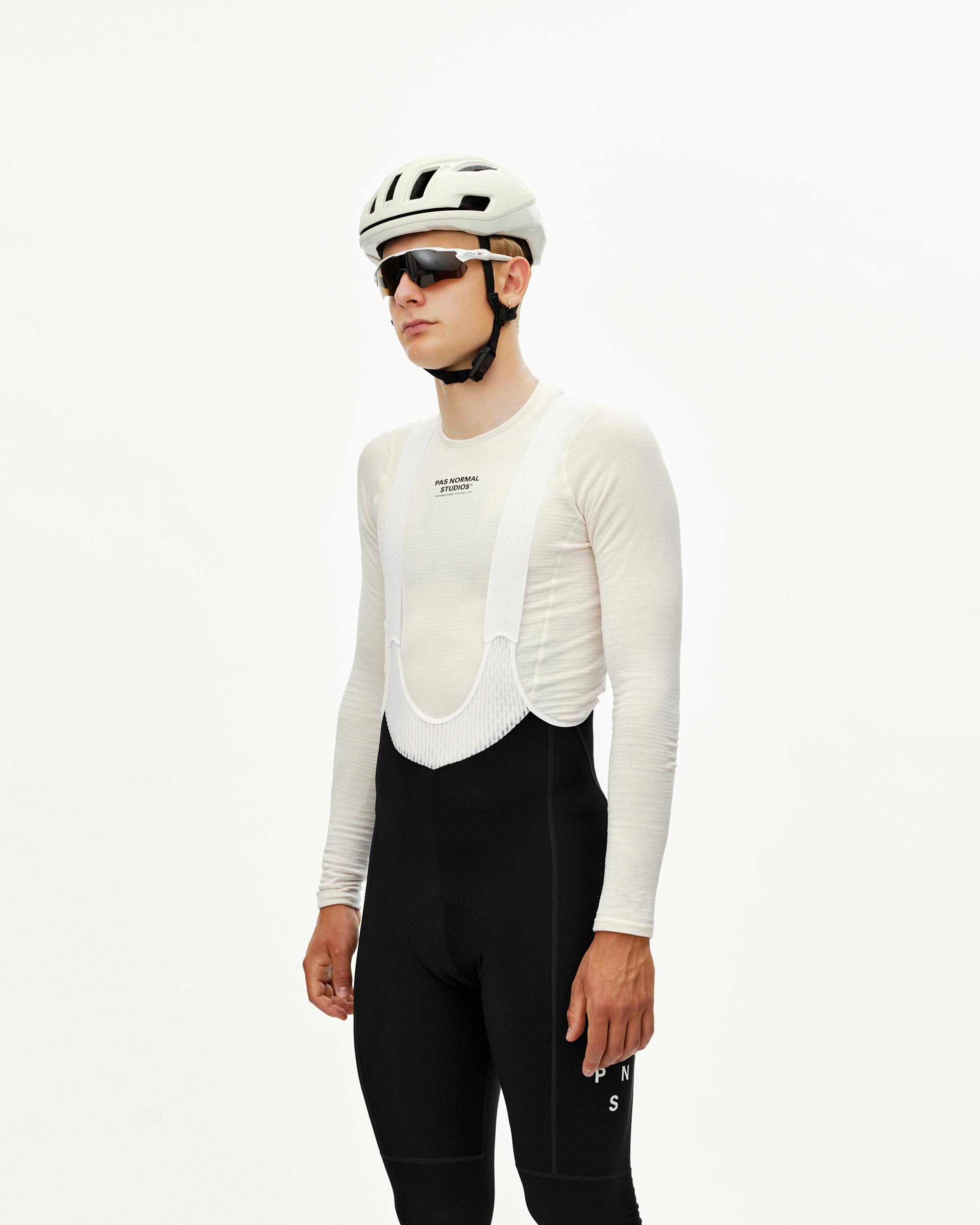 Black Mechanism thermal cycling long bibs on model, front three-quarter view with white bib straps