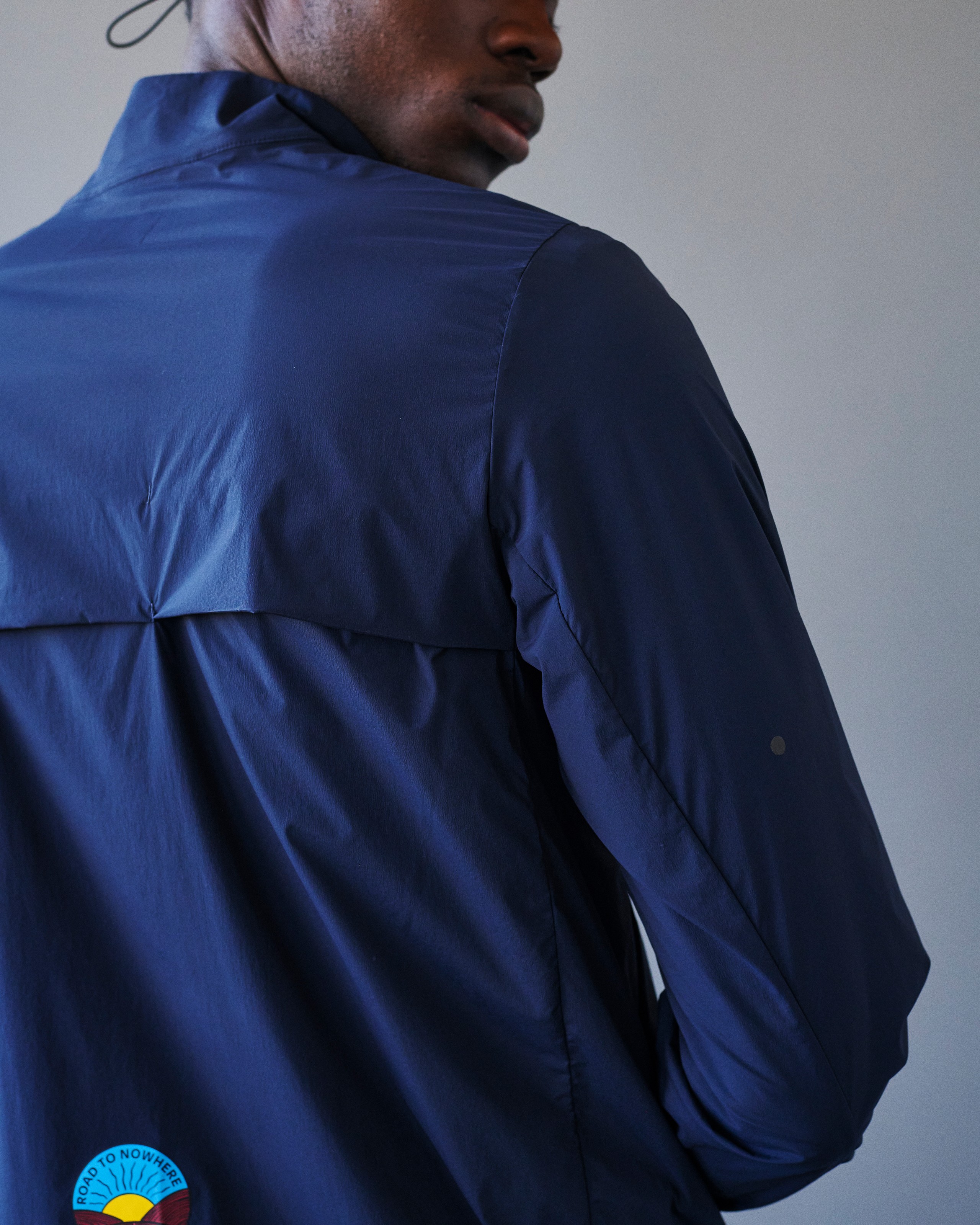 Navy Balance Half Zip jacket on model, rear detail view with back yoke panel and Road to Nowhere badge patch