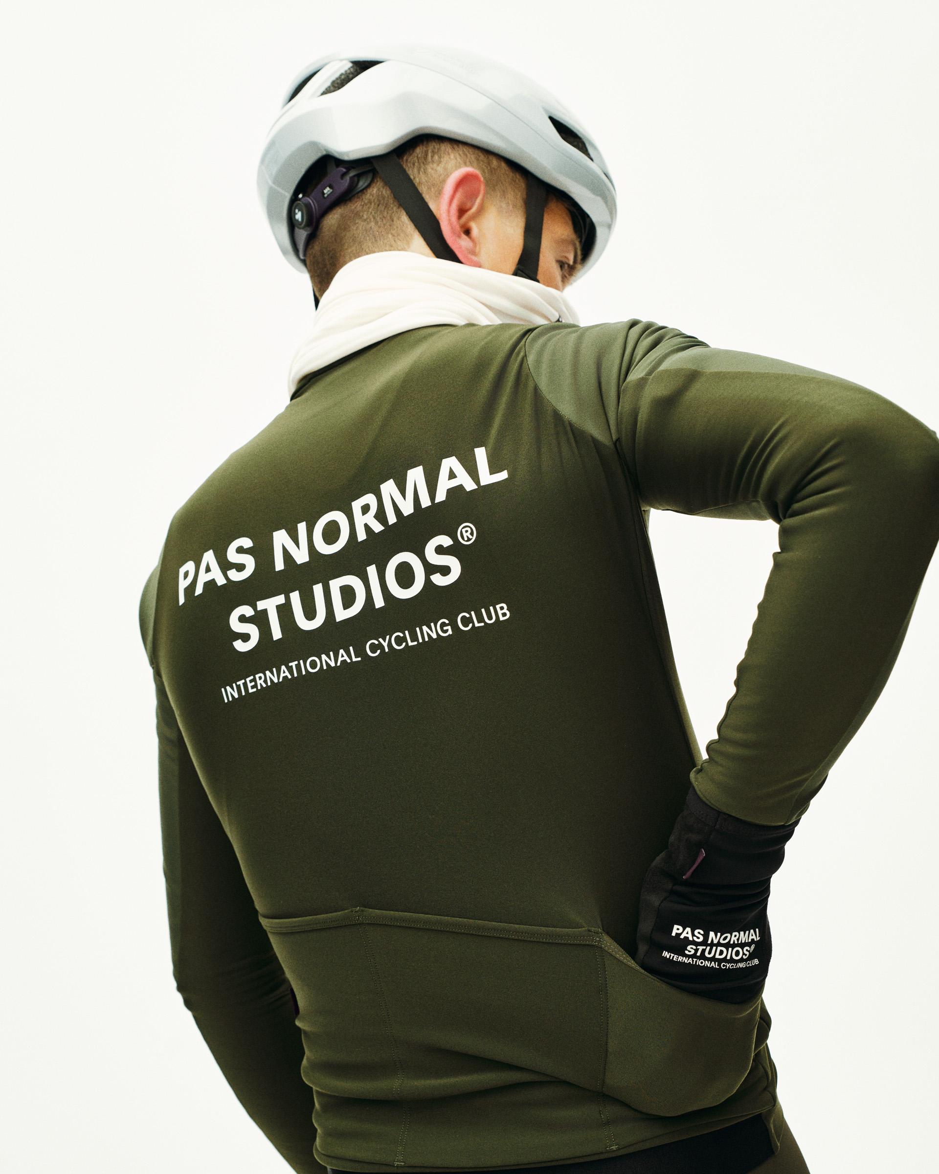 Dark Olive Mechanism Thermal long sleeve cycling jersey on model, rear view with white back print