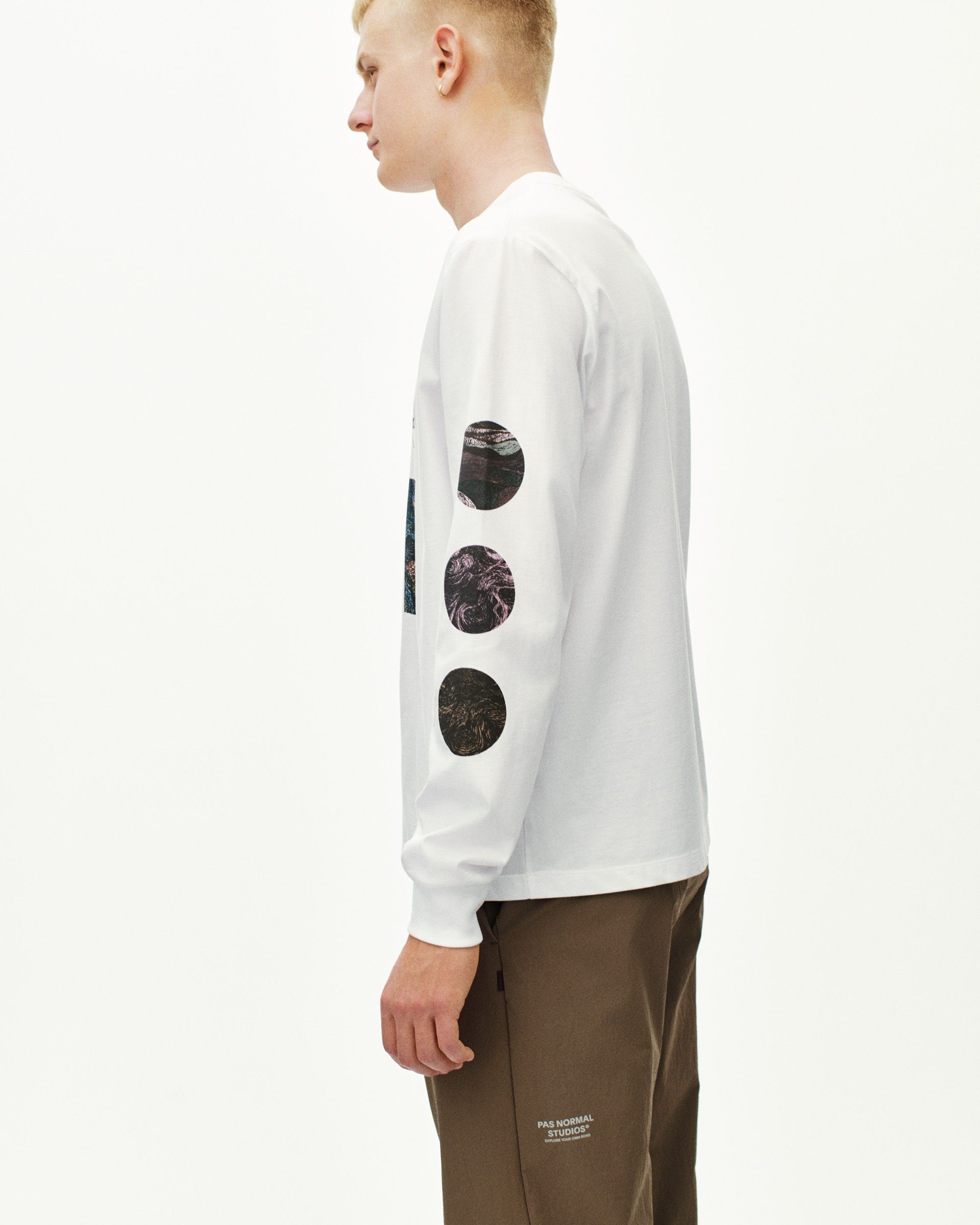 White T.K.O. Off-Race long sleeve T-shirt on model, side view with circular photo prints on sleeve