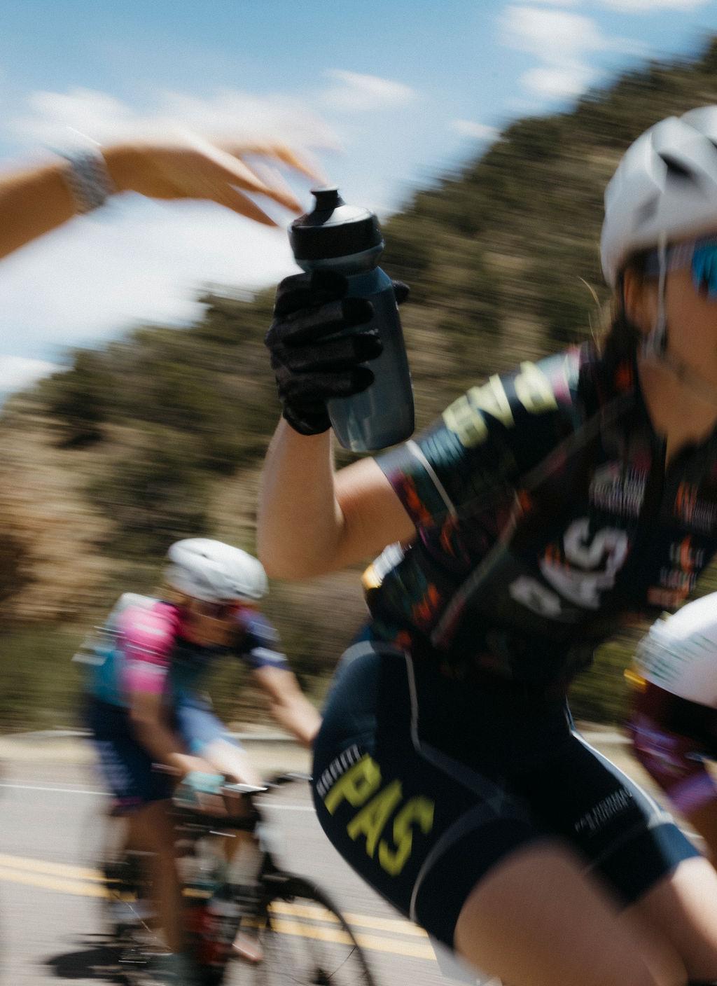 Cyclists in motion blur during Tour of the Gila race, rider drinking from bottle while racing