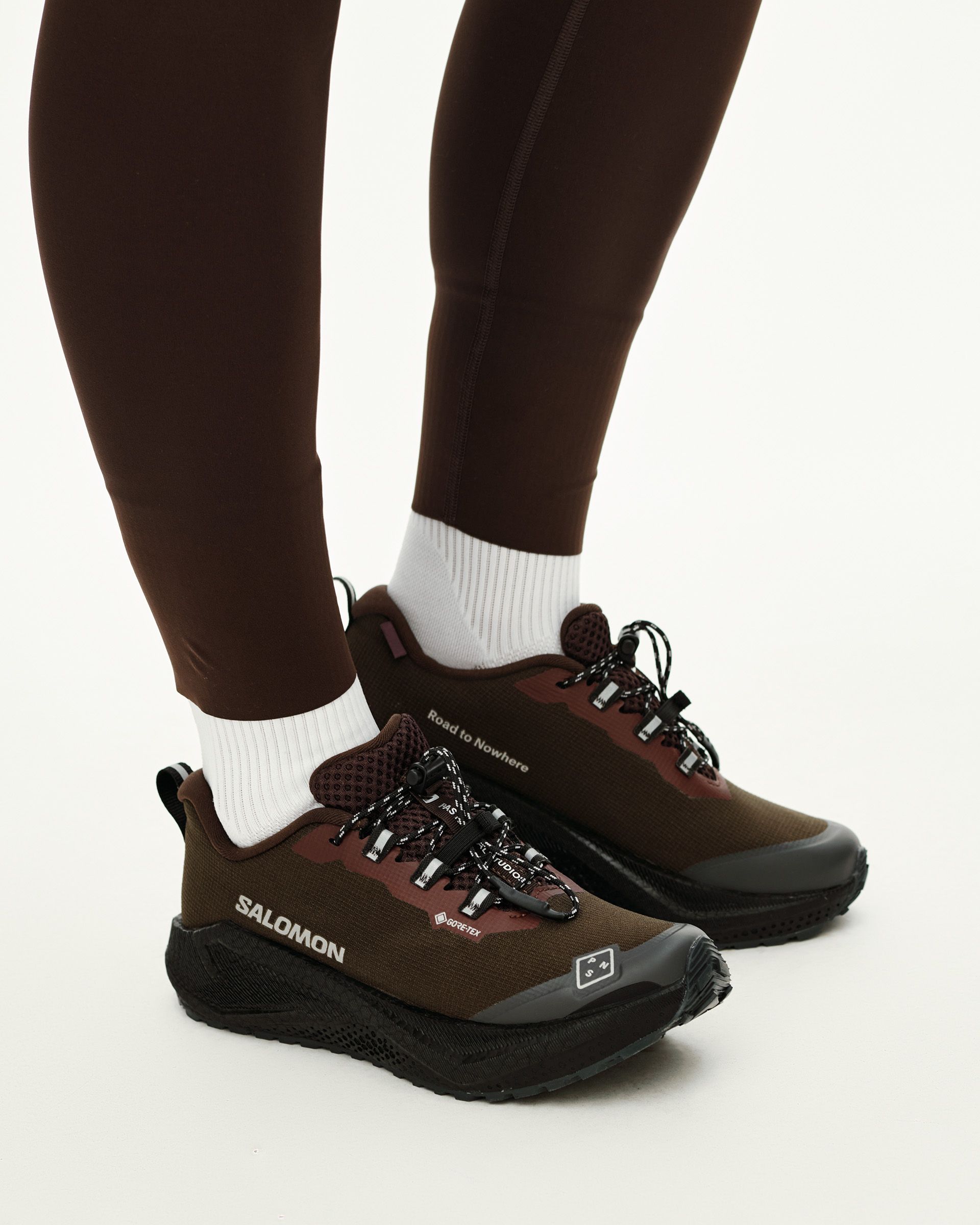Light Brown Salomon AERO BLAZE 4 GRVL GTX trail shoe on model, side view with black sole and contrast lacing