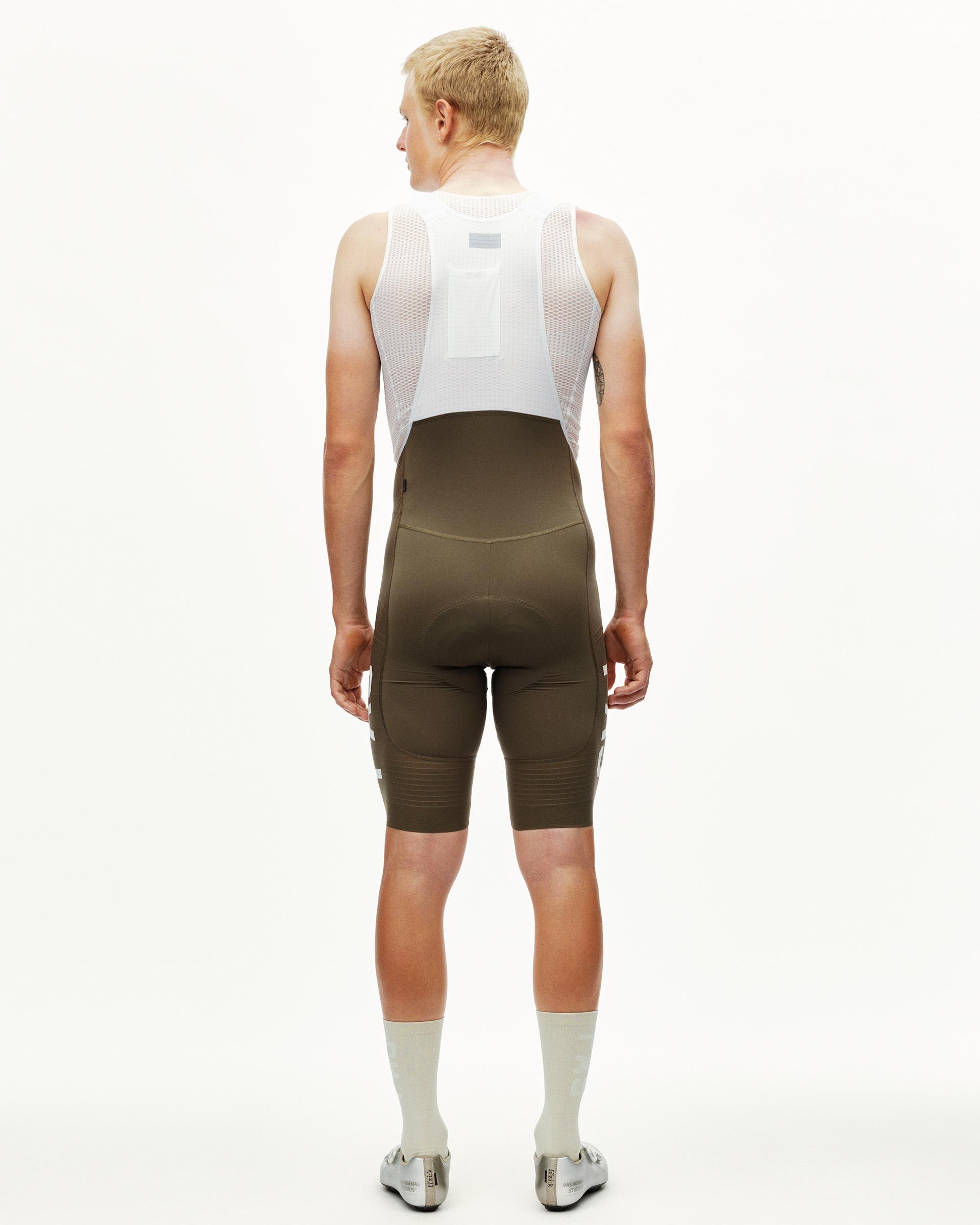 Dark Earth khaki PAS Mechanism Pro cycling bibs on model, rear view with white mesh bib straps