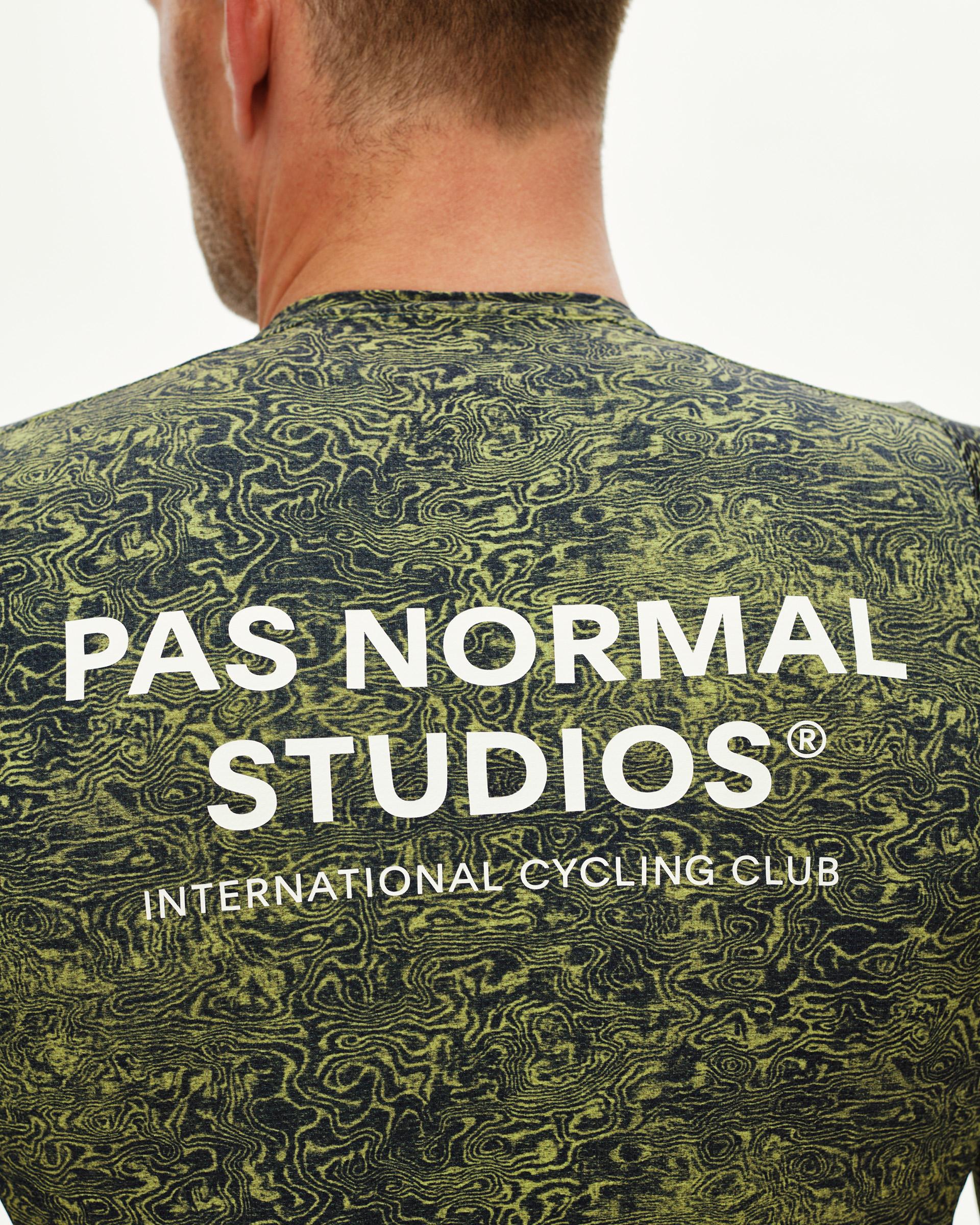 Dark Lime Essential cycling jersey, rear detail on model with topographic AOP and white back logo print