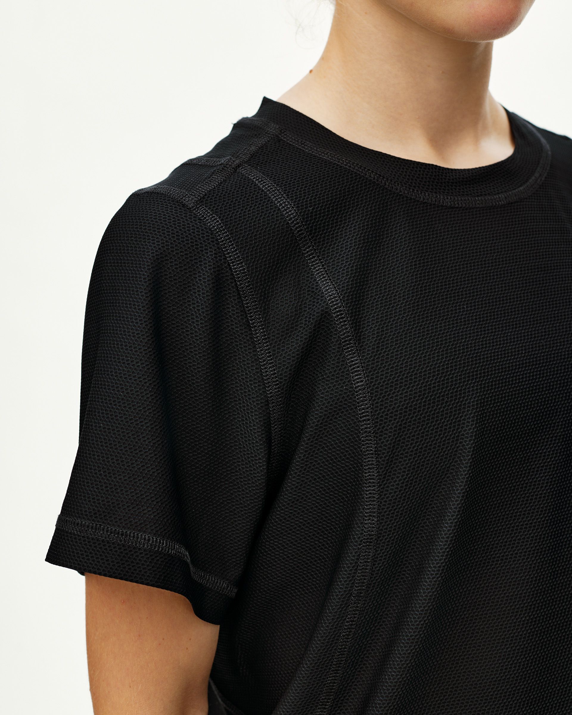 Black Balance T-shirt on model, front detail view with textured mesh fabric and contrast seam stitching