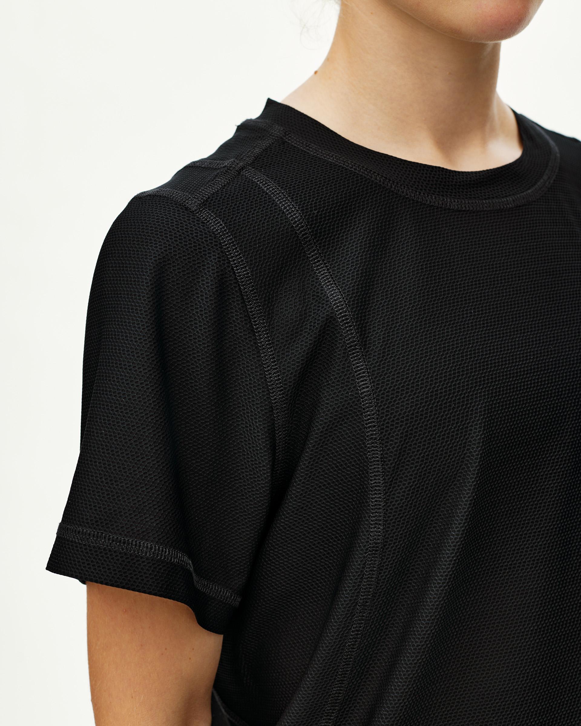 Black Balance T-shirt on model, front detail view with textured mesh fabric and contrast seam stitching