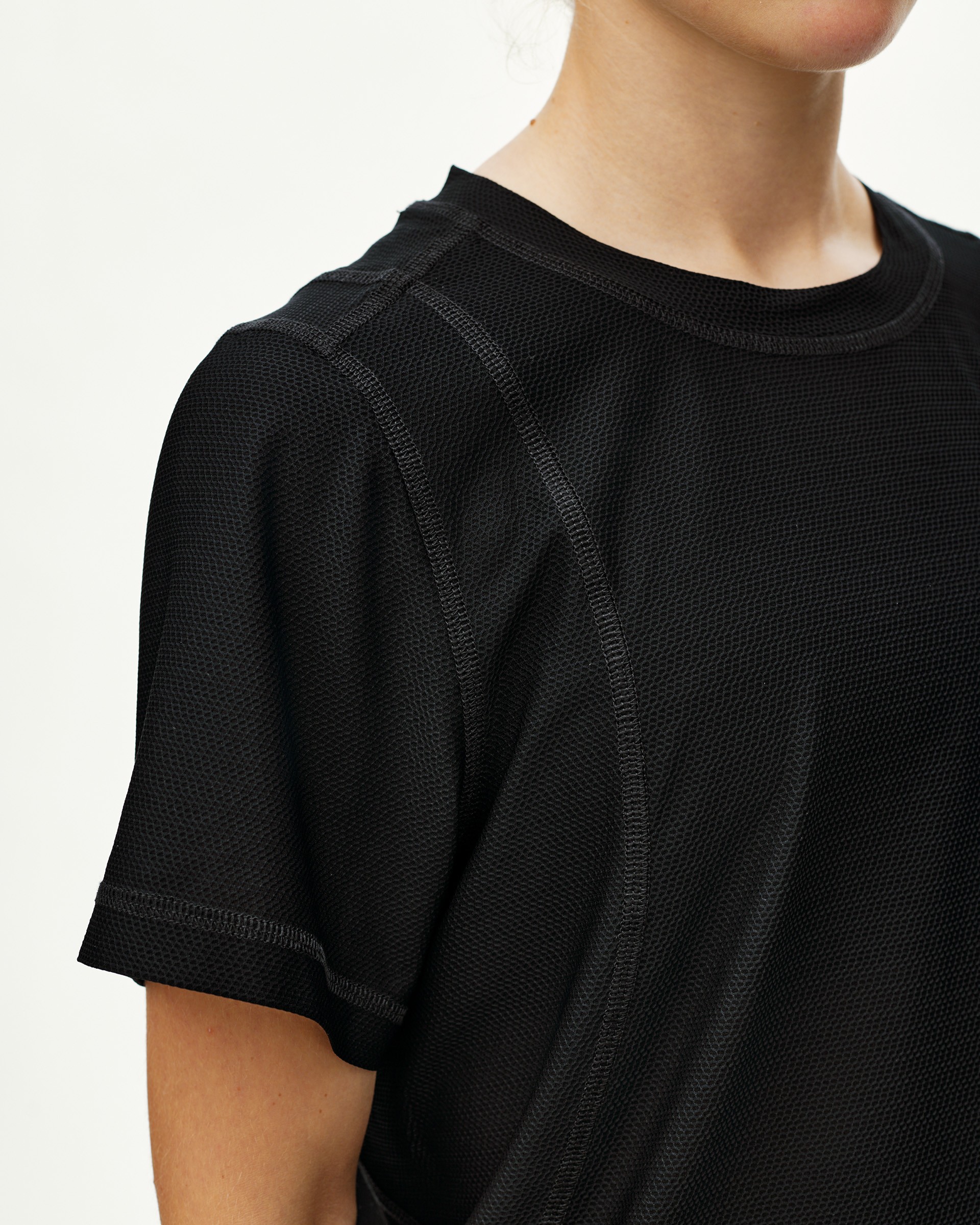 Black Balance T-shirt on model, front detail view with textured mesh fabric and contrast seam stitching