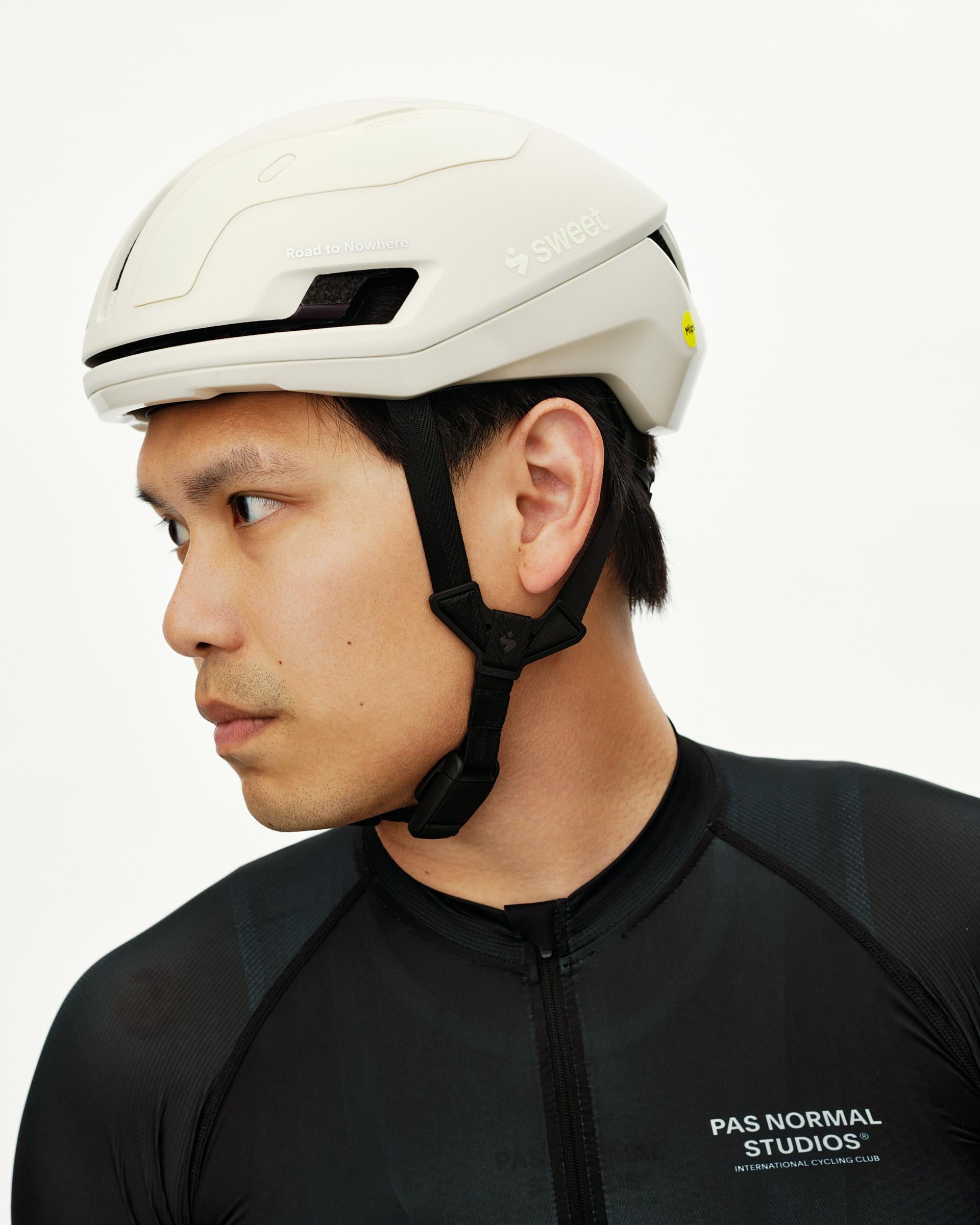 Off White Sweet Protection Falconer Aero 2Vi MIPS Round Fit cycling helmet, side view on model with black chin strap