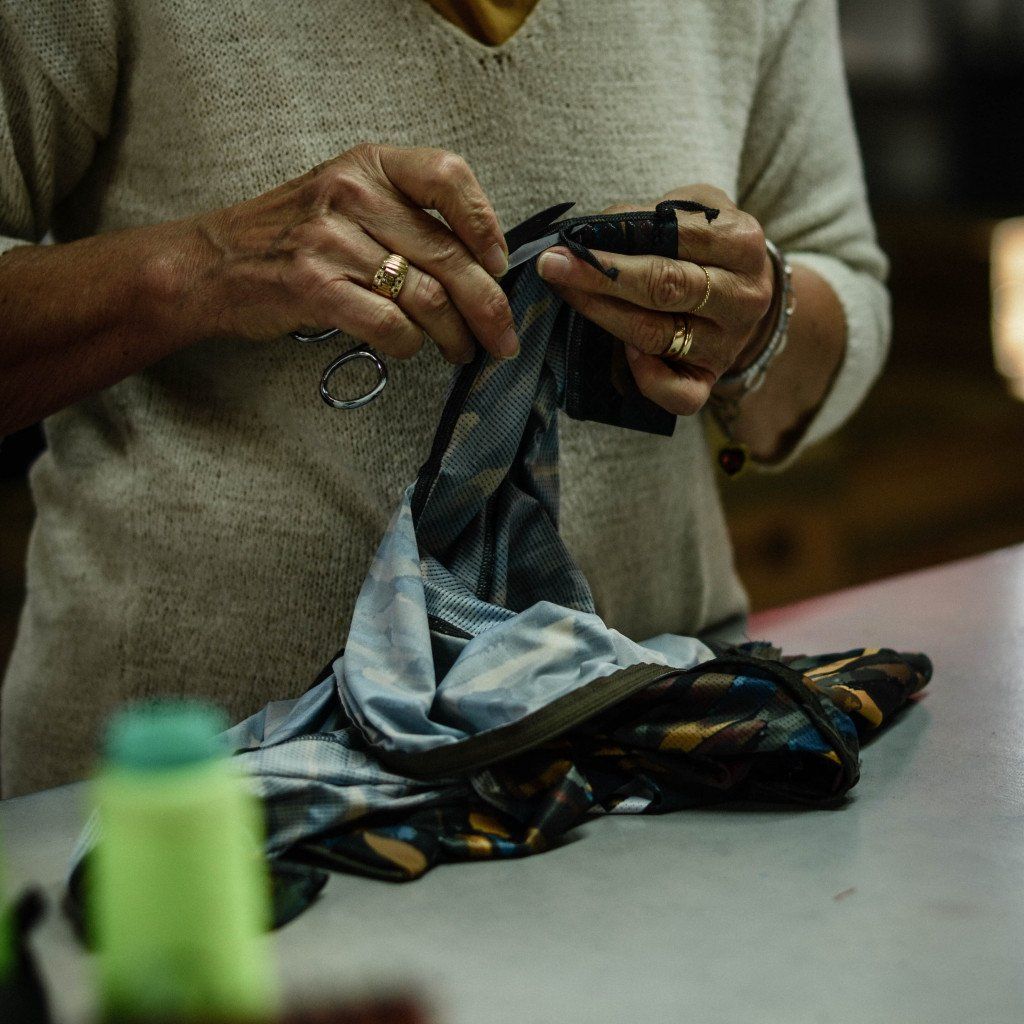 Hands holding cycling apparel showing fabric details and construction process
