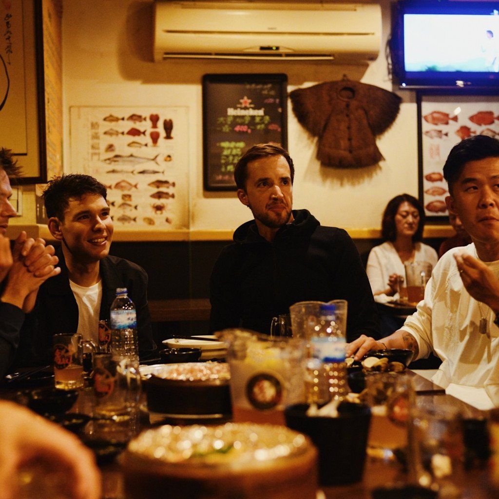 Group dining at Japanese restaurant with cycling team members in casual wear