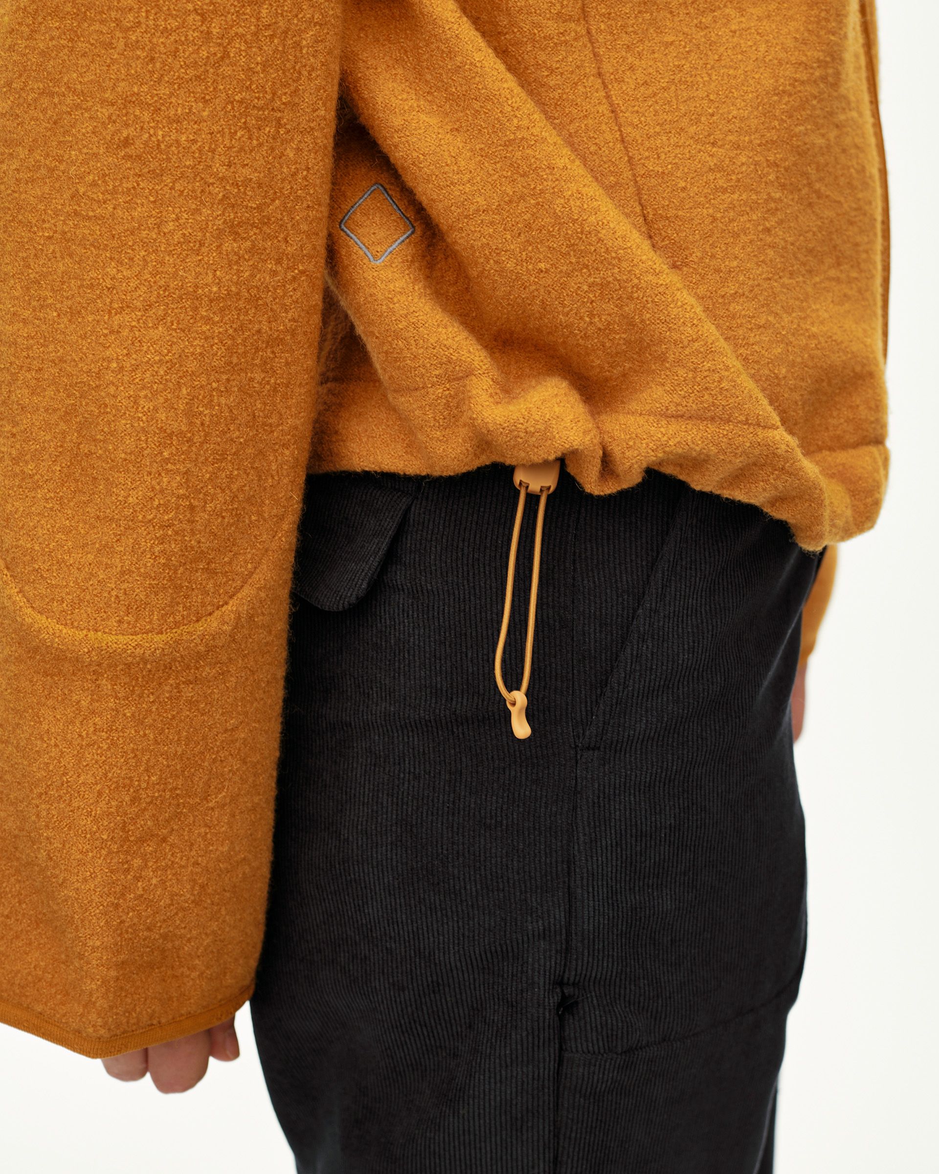 Ochre Off-Race Boiled Wool jacket, side detail on model with drawcord hem toggle