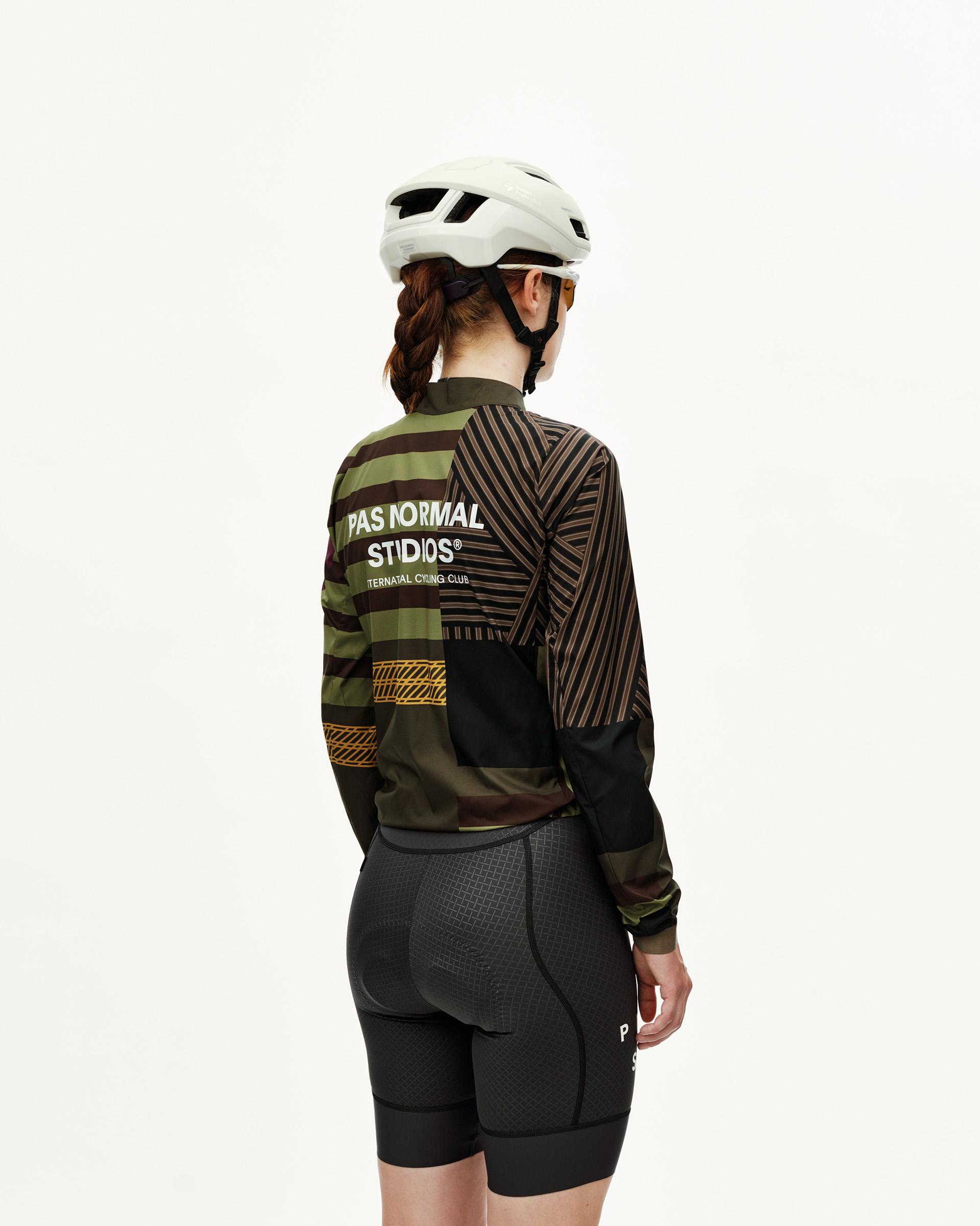 International Green Mechanism Stow Away women's cycling jacket on model, rear view with mixed stripe and geometric print